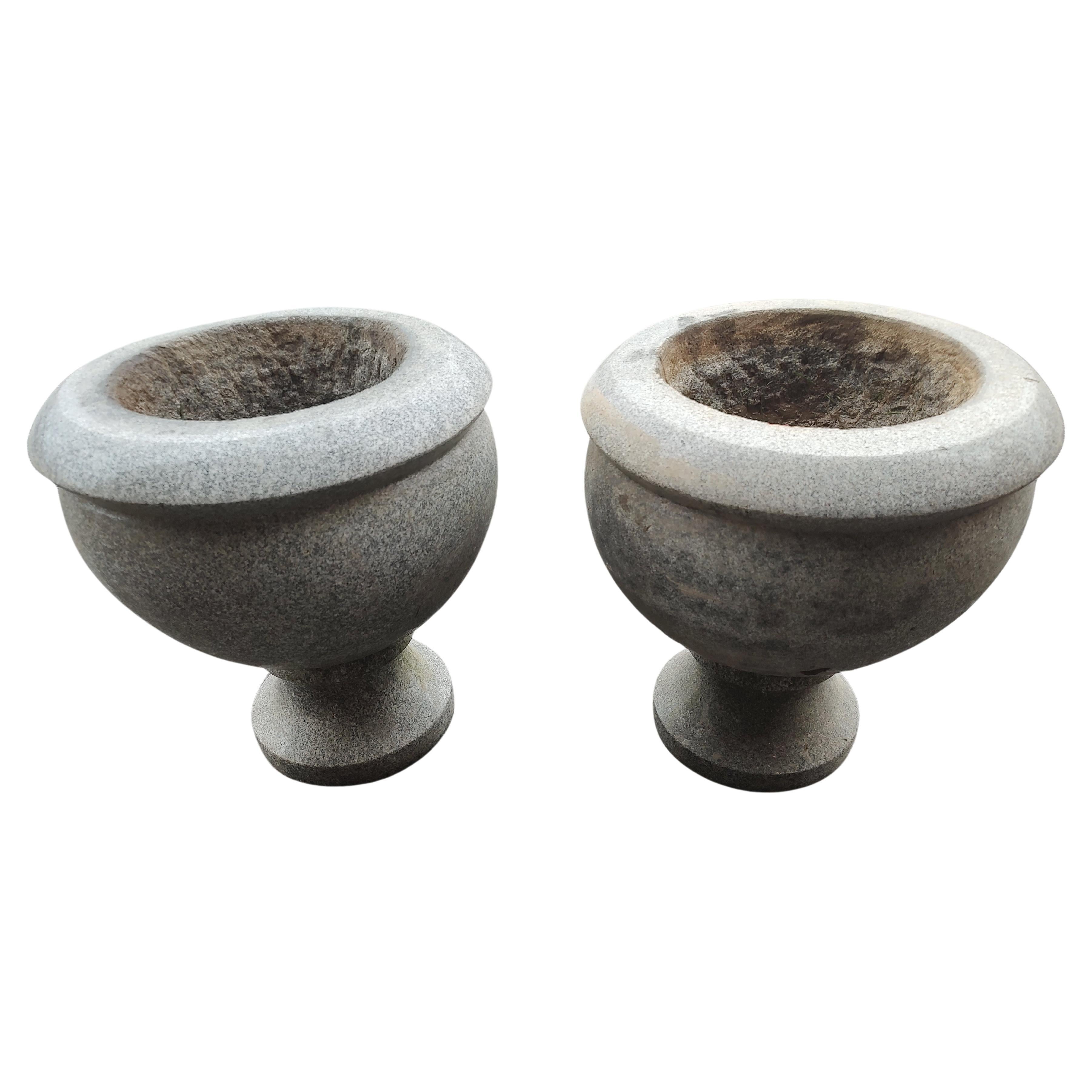 Simple and elegant pair of polished Art Deco granite urns, planters. Hand chiseled, rough cut marks on bottom and interior of the pots to indicate this. Opening is 10w x 5 deep.Polished out these will gleam if so desired. Priced & sold as a pair.