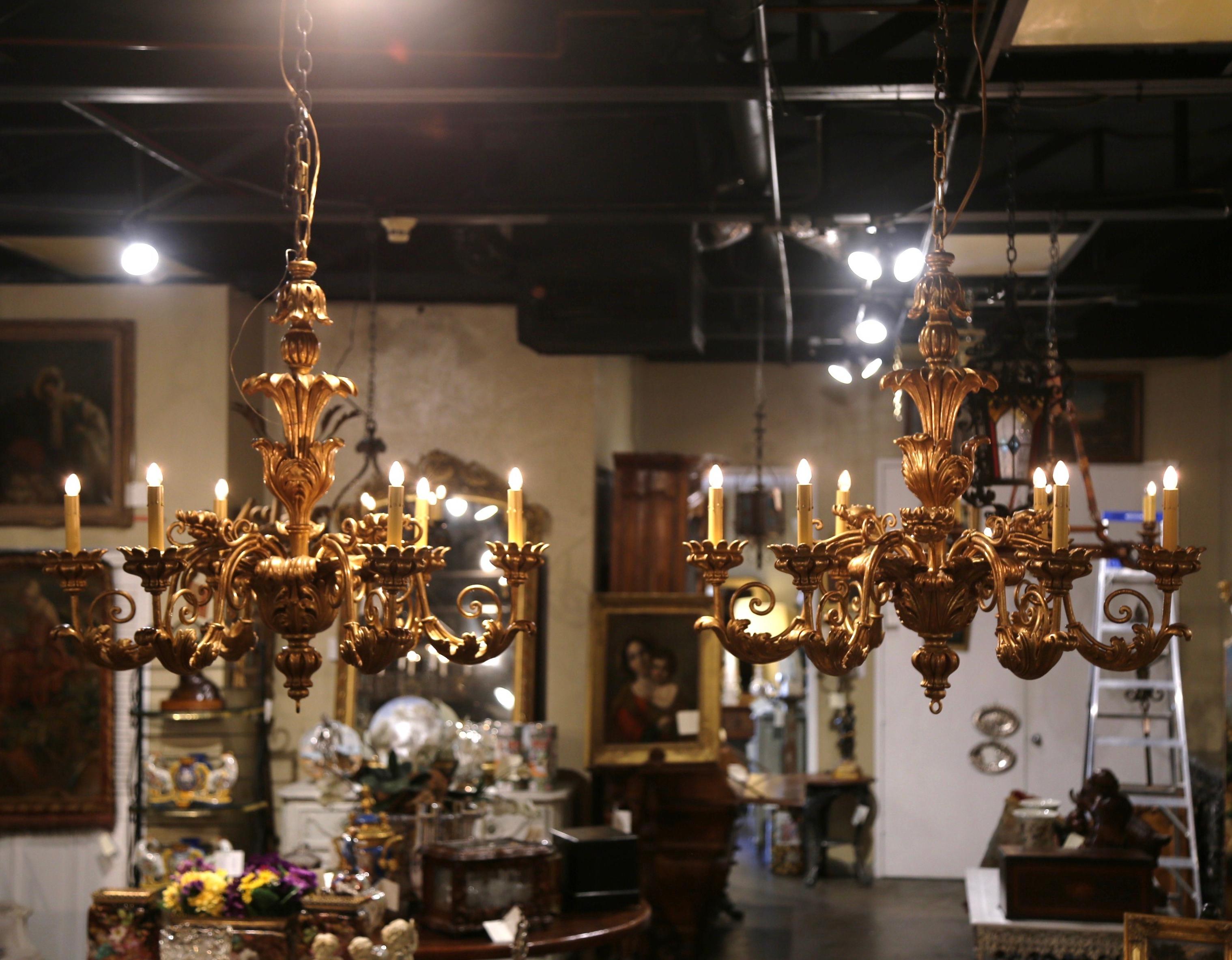 Decorate a grand foyer, dining room, or even a formal sitting area with this elegant pair of antique carved gilt wood chandeliers. Hand carved in Italy circa 1920, each Italian-inspired fixture beautifully captures the elegance of Italian styles,
