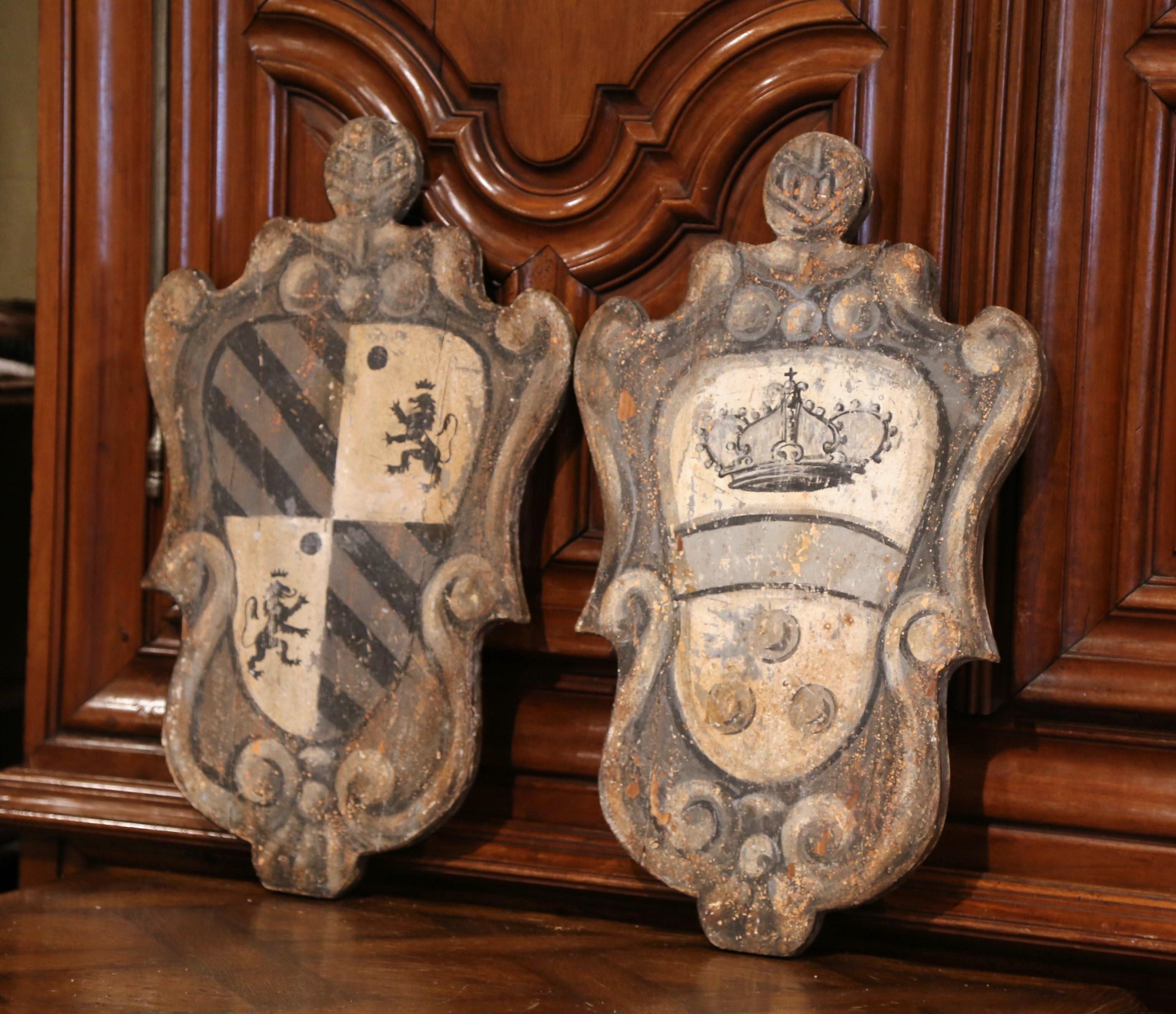 Decorate a game room or a study with this colorful pair of carved antique plaques. Crafted in southern Italy, circa 1920, the painted wall sculptures feature a center oval medallion decorated with two different coat of arms with lion figure and
