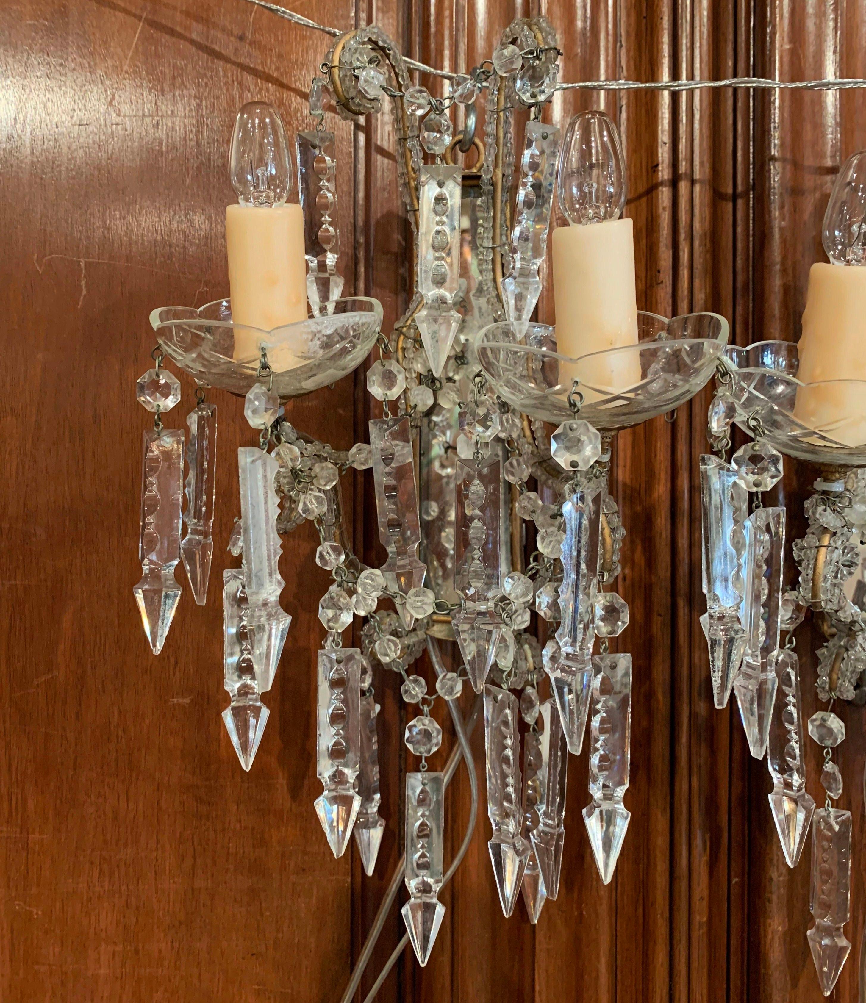 Bring elegance to a powder room with this pair of antique light fixtures; crafted in Italy circa 1920, each sconce with back mirror plate, features two arms newly wired embellished with wax candles, and decorated with cut crystal and pendants over