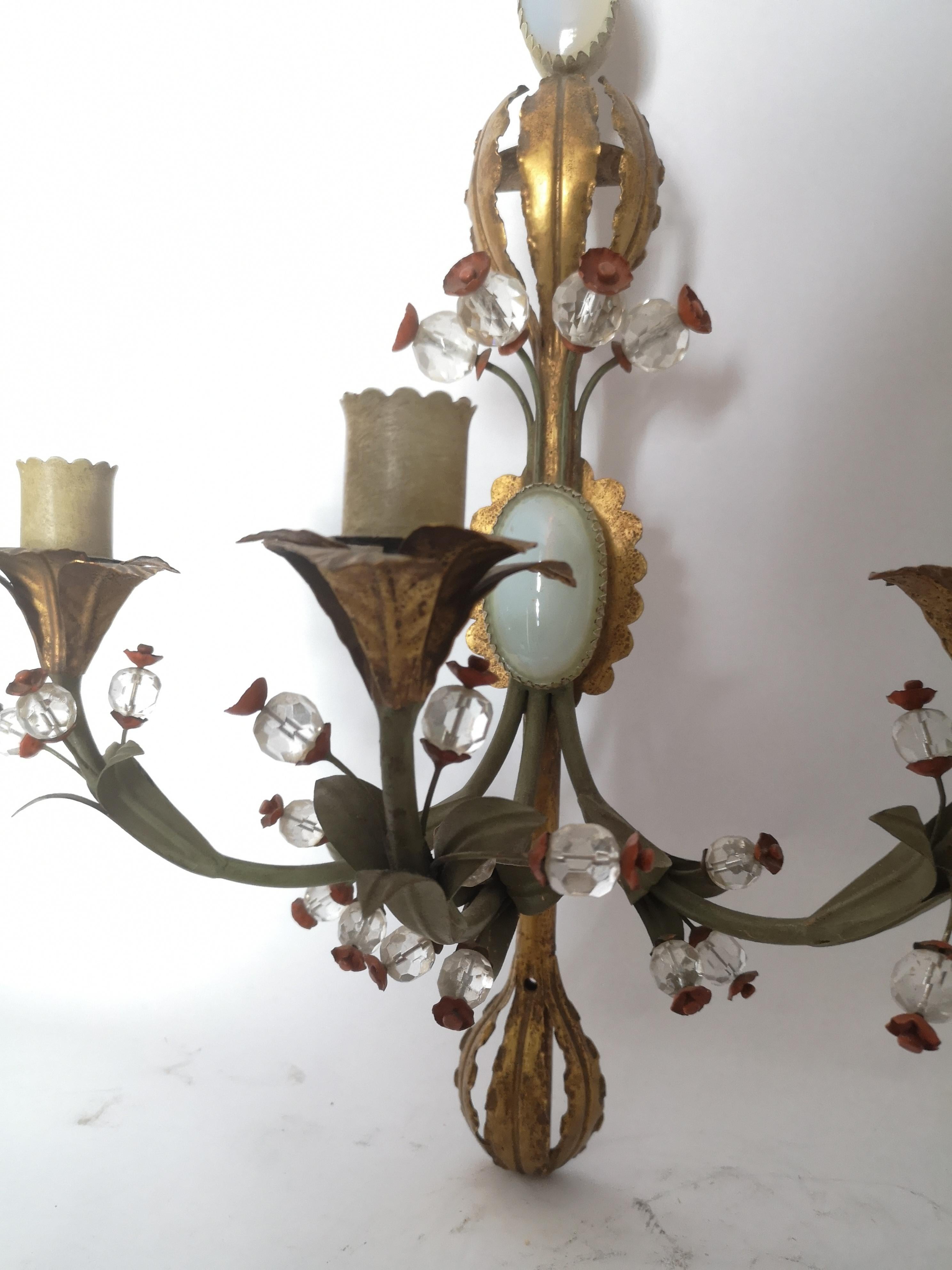 Pair of very decorative early 20th century Italian toleware wall lights. Each with three sconces for bulbs, in original green and gold painted metal, inset two opaline panels and glass beads with red metal flowers.
Can be wired for your country of