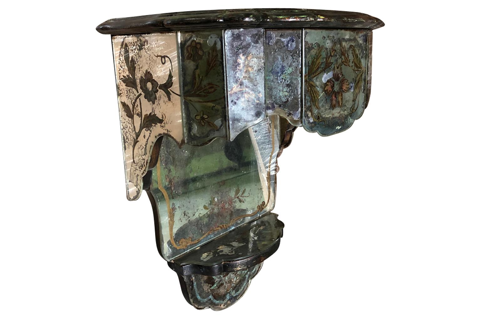 A very wonderful pair of early 20th century wall mounted Venetian mirrored consoles, each with one drawer and lovely floral paintings. Very chic.