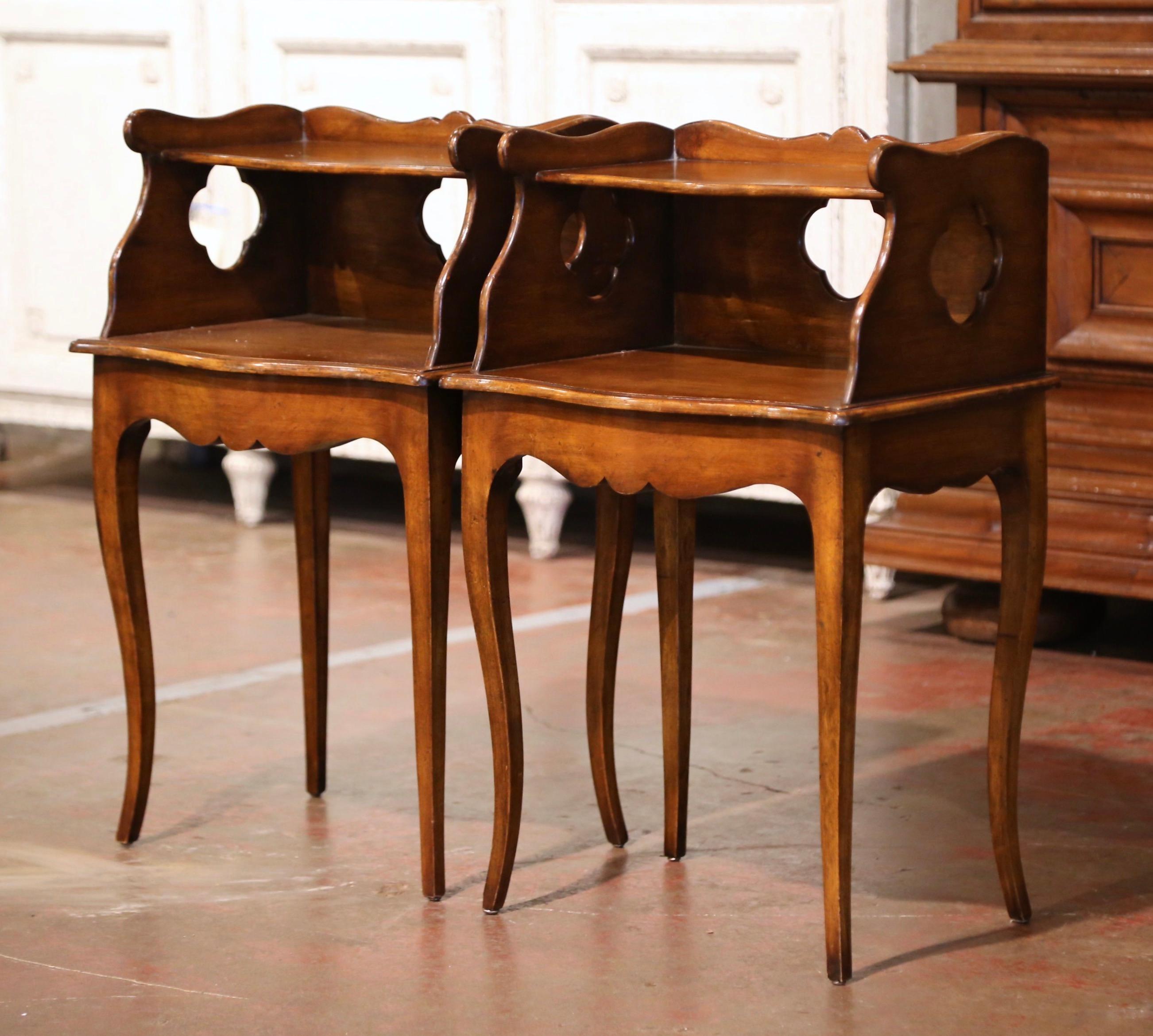 These elegant antique tables were created in Provence, France, circa 1920. Each fruitwood cabinet stands on cabriole legs over a bombe and scalloped apron. The table features a two-tier plateau with pierced sides and back in between, and the top