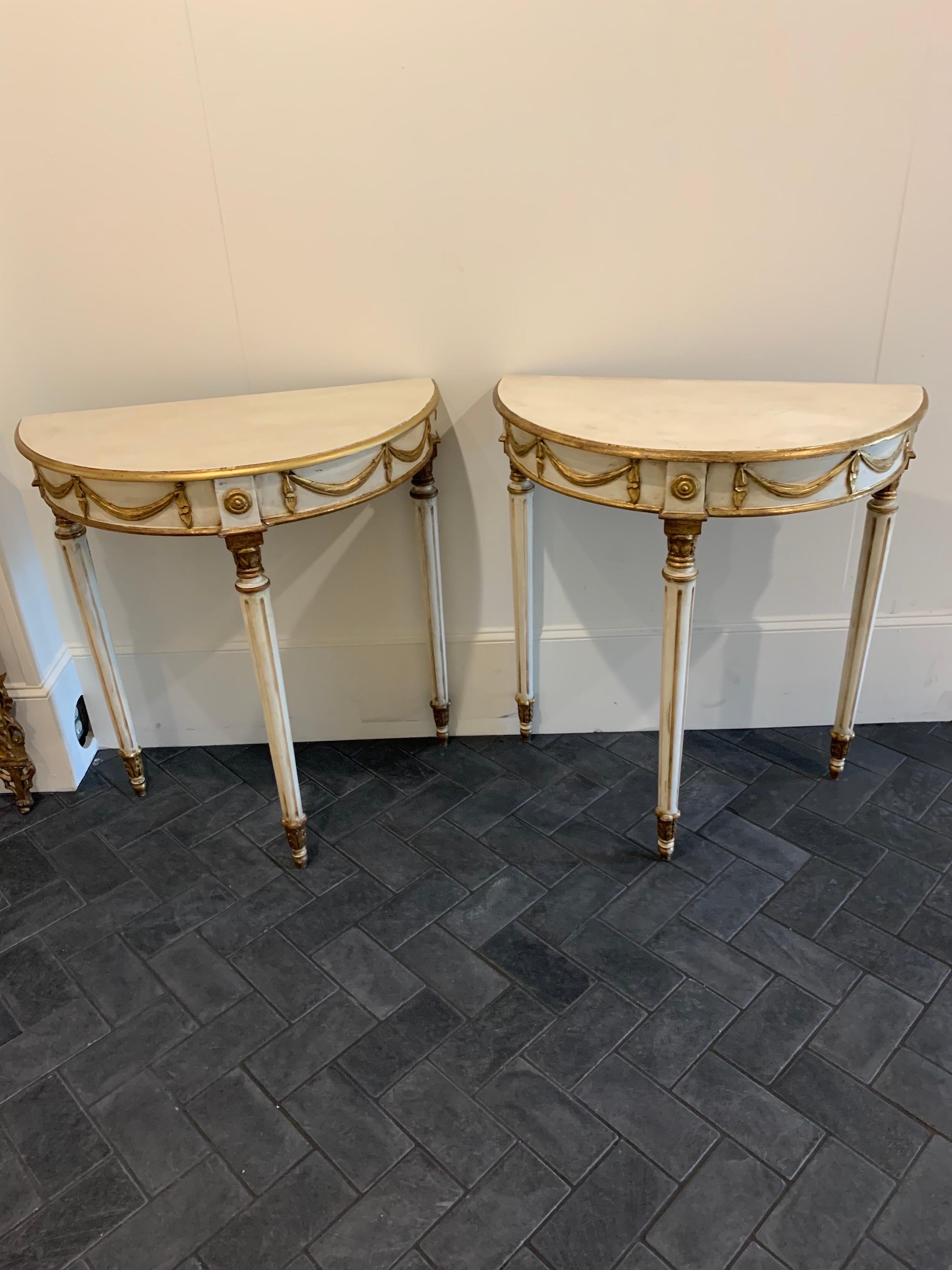 Lovely pair of early 20th century Louis XVI style parcel-gilt side tables. Painted in a creamy white with nicely carved gold gilt details. This pair creates a very Classic look and is great for a smaller spaces. So pretty!