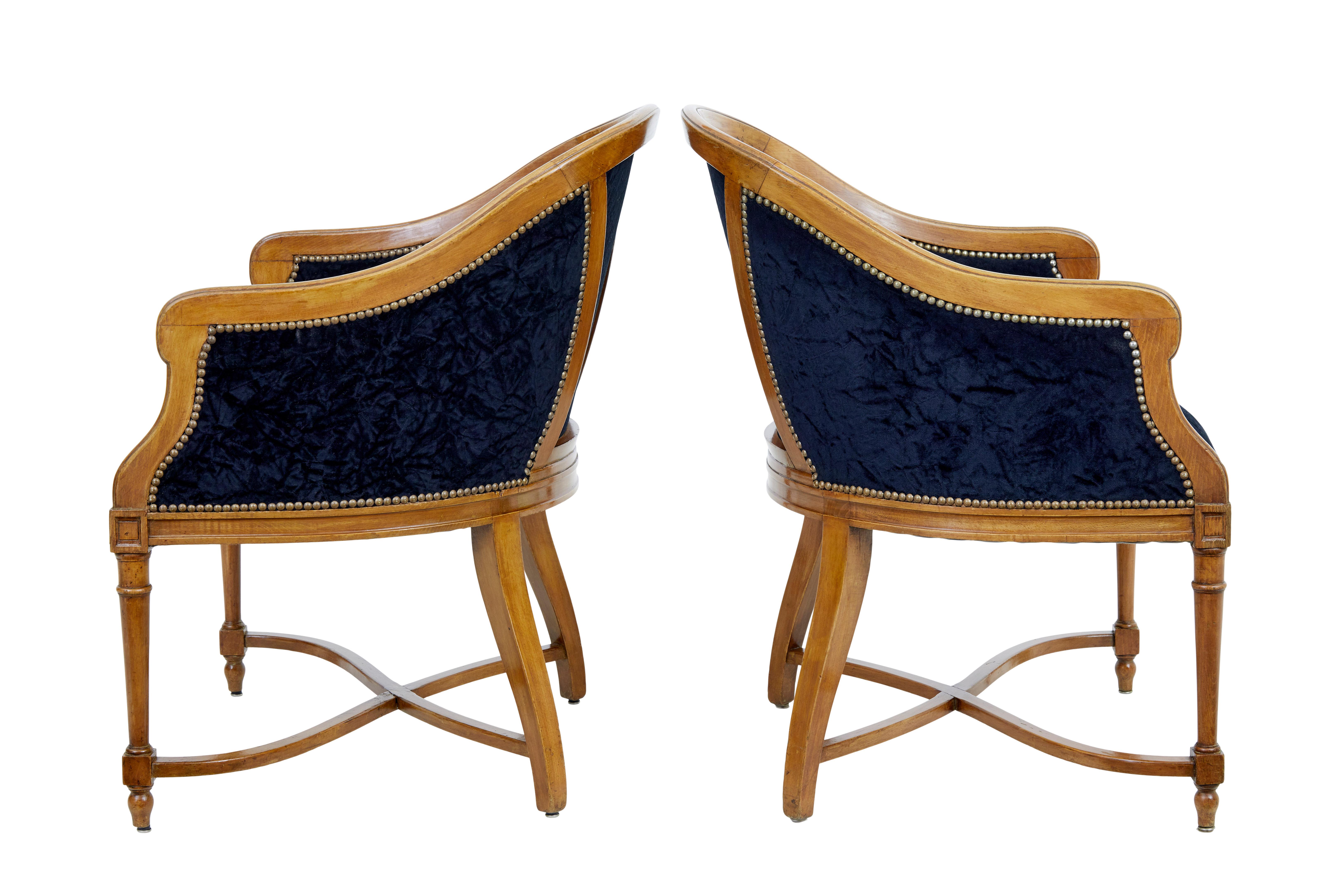 Pair of early 20th century lounge chairs circa 1910.

Good quality pair of hand crafted chairs made in beech and stained to look like elm.

Very comfortable chairs, richly upholstered in dark blue crushed velvet and decorated with brass stud work. 