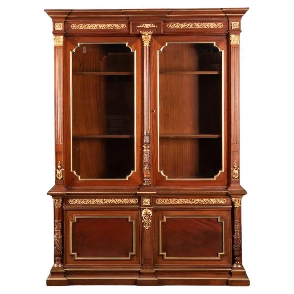 Pair of mahogany Russian bibliotheques from the early 20th century.
 
In carved mahogany with applied gilt-bronze mounts, the molded and stepped pediment over glazed double doors with two interior shelves over two drawers and two cabinet doors.
