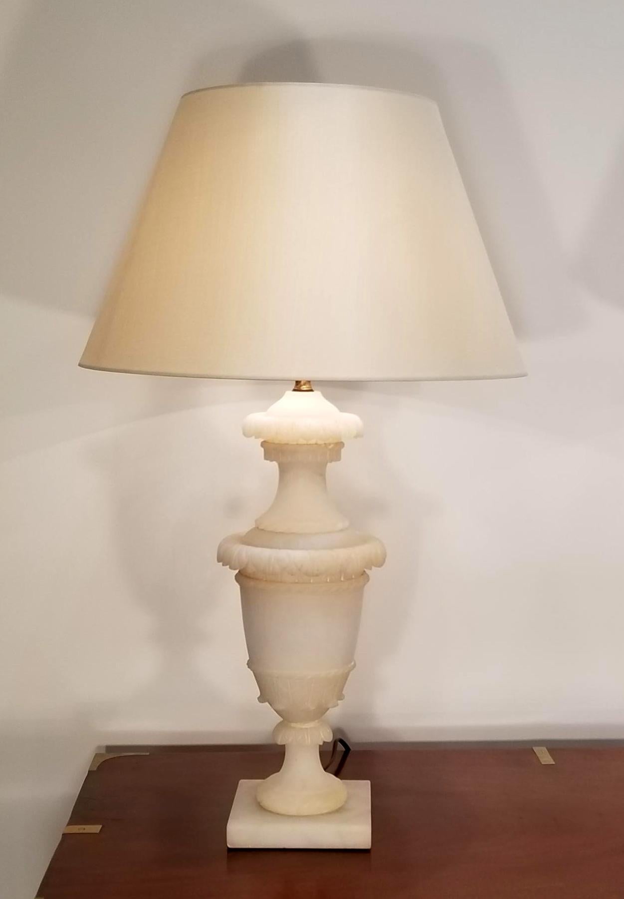 These elegant classically carved Alabaster urns are mounted as beautiful lamps.

One minor chip on the bottom of the back on one of the lamp bases. 

Additional Measurements:
Diameter without shade 7.25 inches
Diameter with shade 15.75 inches.