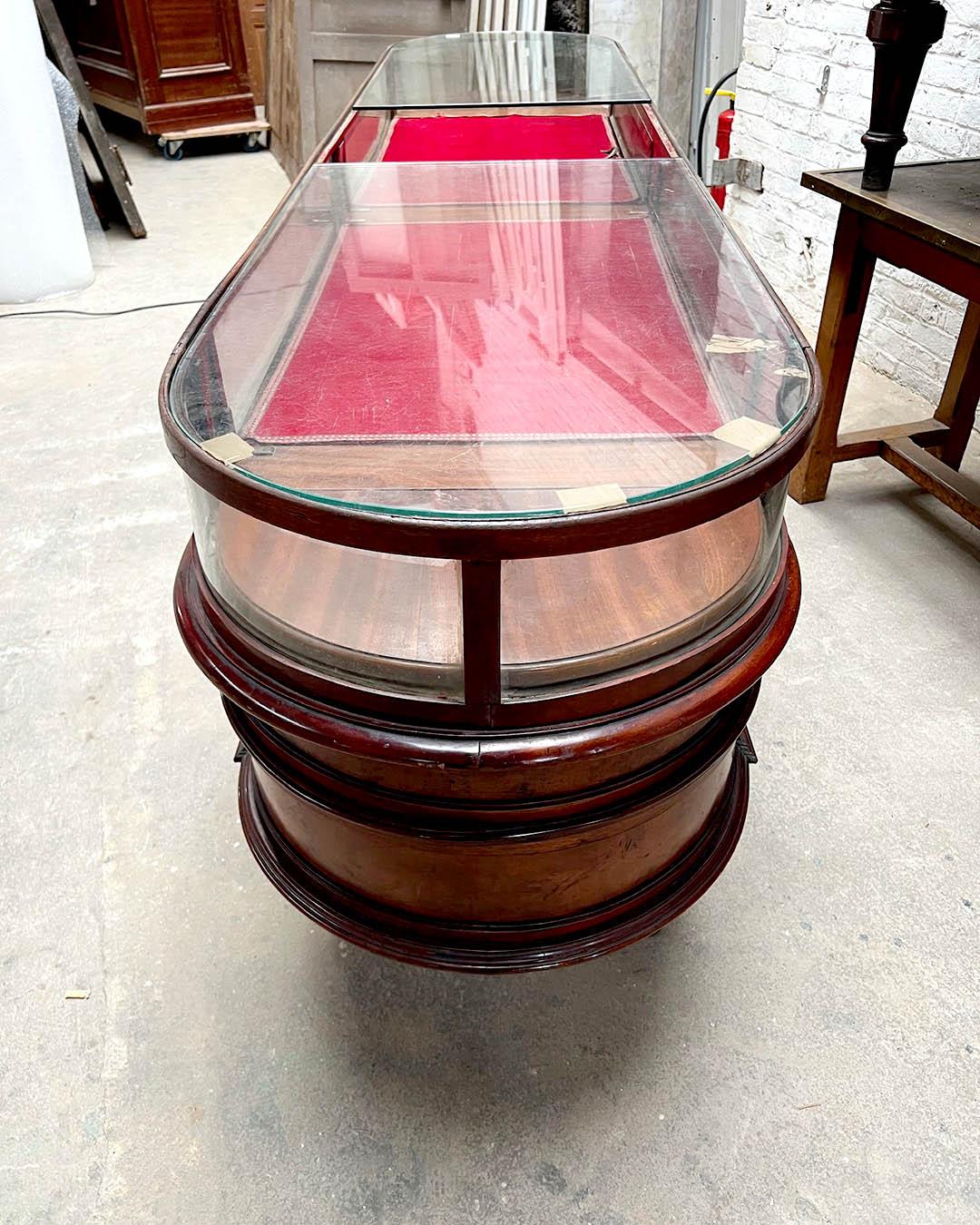 A rare and impressive pair of large Palermitan display cabinets, dating from the early 20th century (circa 1900–1910). These vitrines are masterfully crafted in mahogany with rich patina and elegant brass mounts. Their elongated oval form, gently