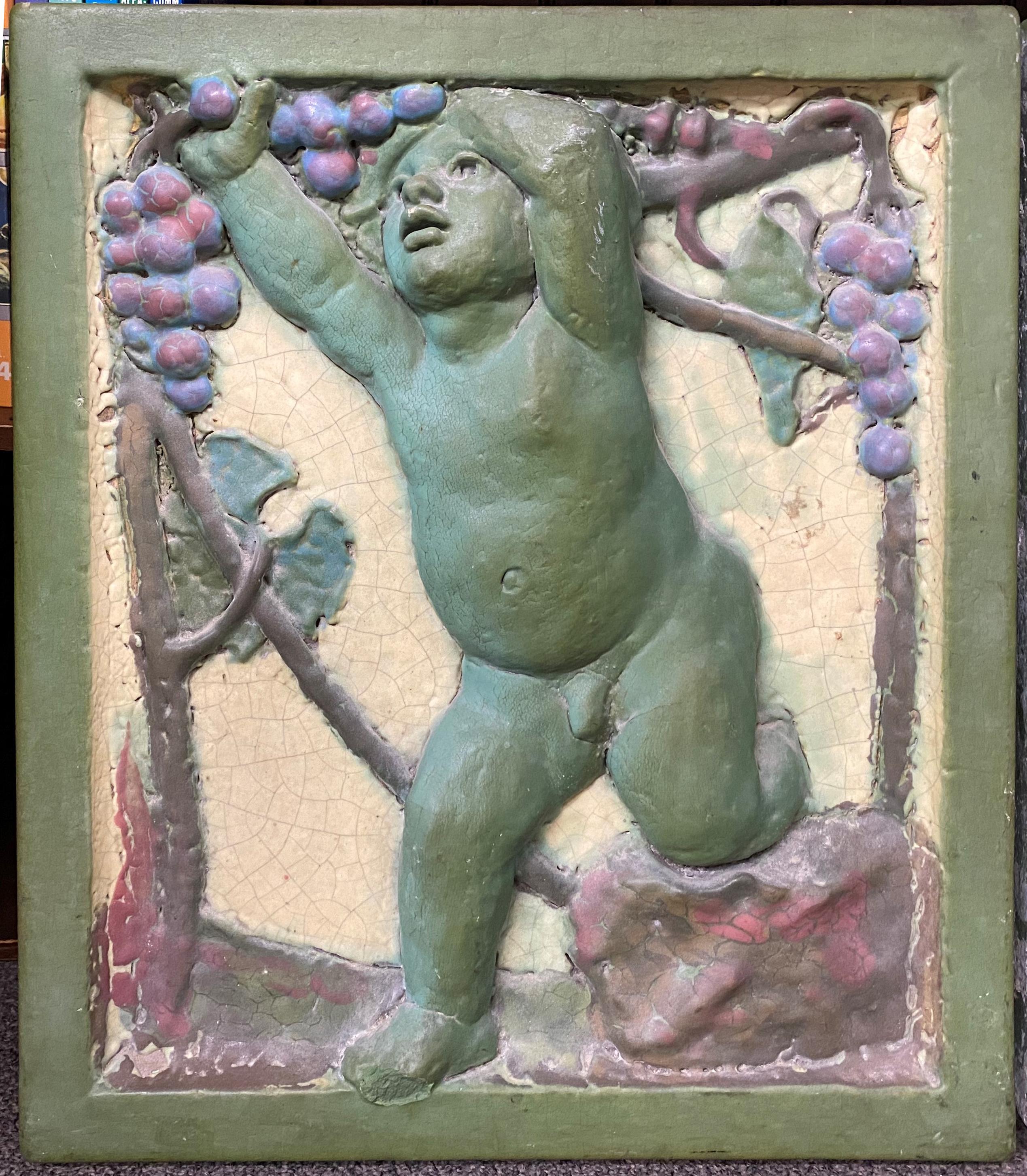 A fine pair of heavy cast polychrome architectural tiles featuring a single putto on each with a grape motif and green border, one dated 1921 on verso, and one illegibly stamped on verso. Probably English in origin, in very good overall condition,