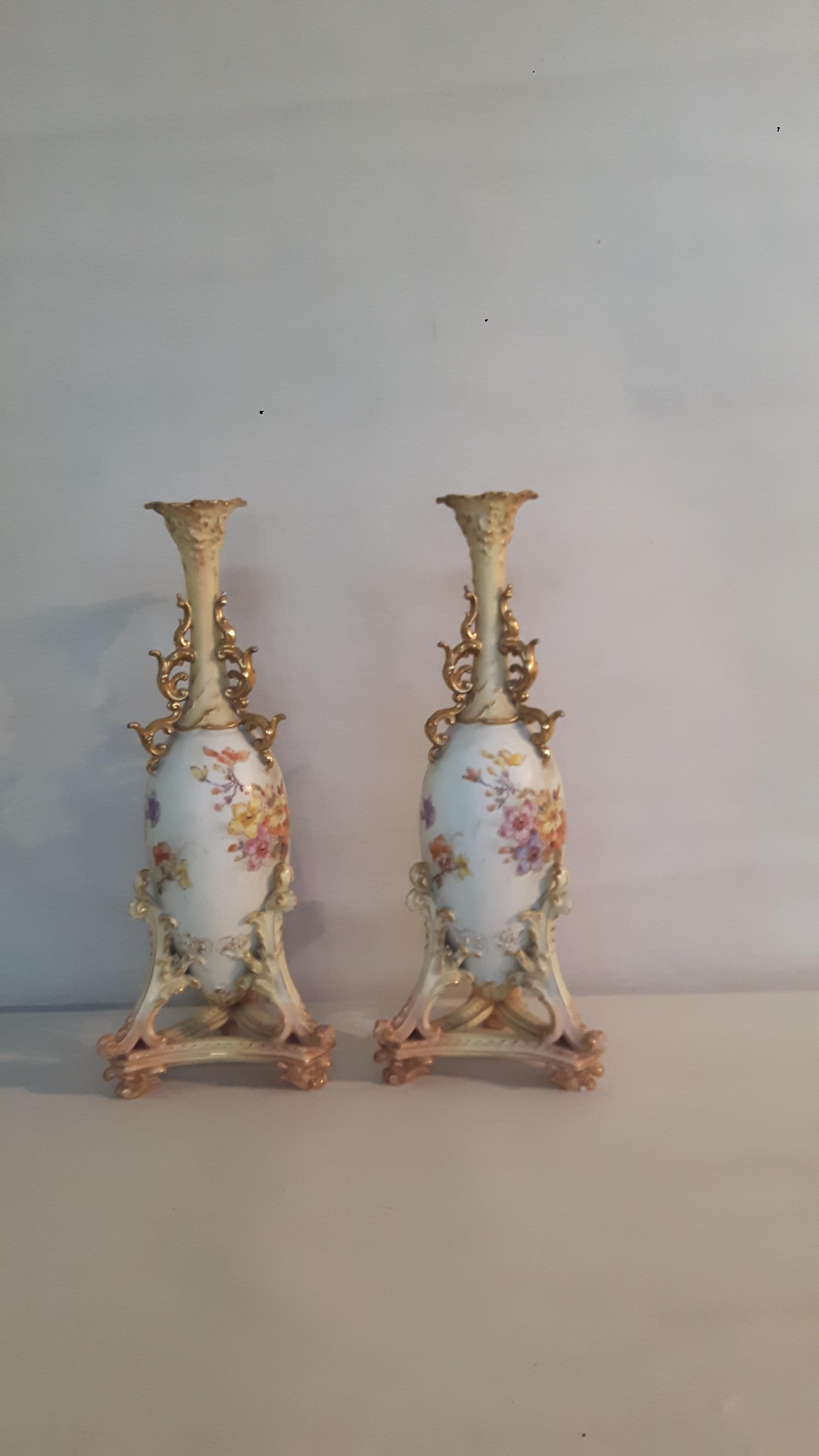 Ein Paar Rudolfstädter Porzellanvasen, ganz im Stil von Royal Worcester, handbemalt mit floralen Motiven auf einem Enteneier-Fond; der Hals und der Fuß der Vasen sind mit Biskuit- und vergoldeten Schnörkeln verziert, die Hälse mit einer vergoldeten