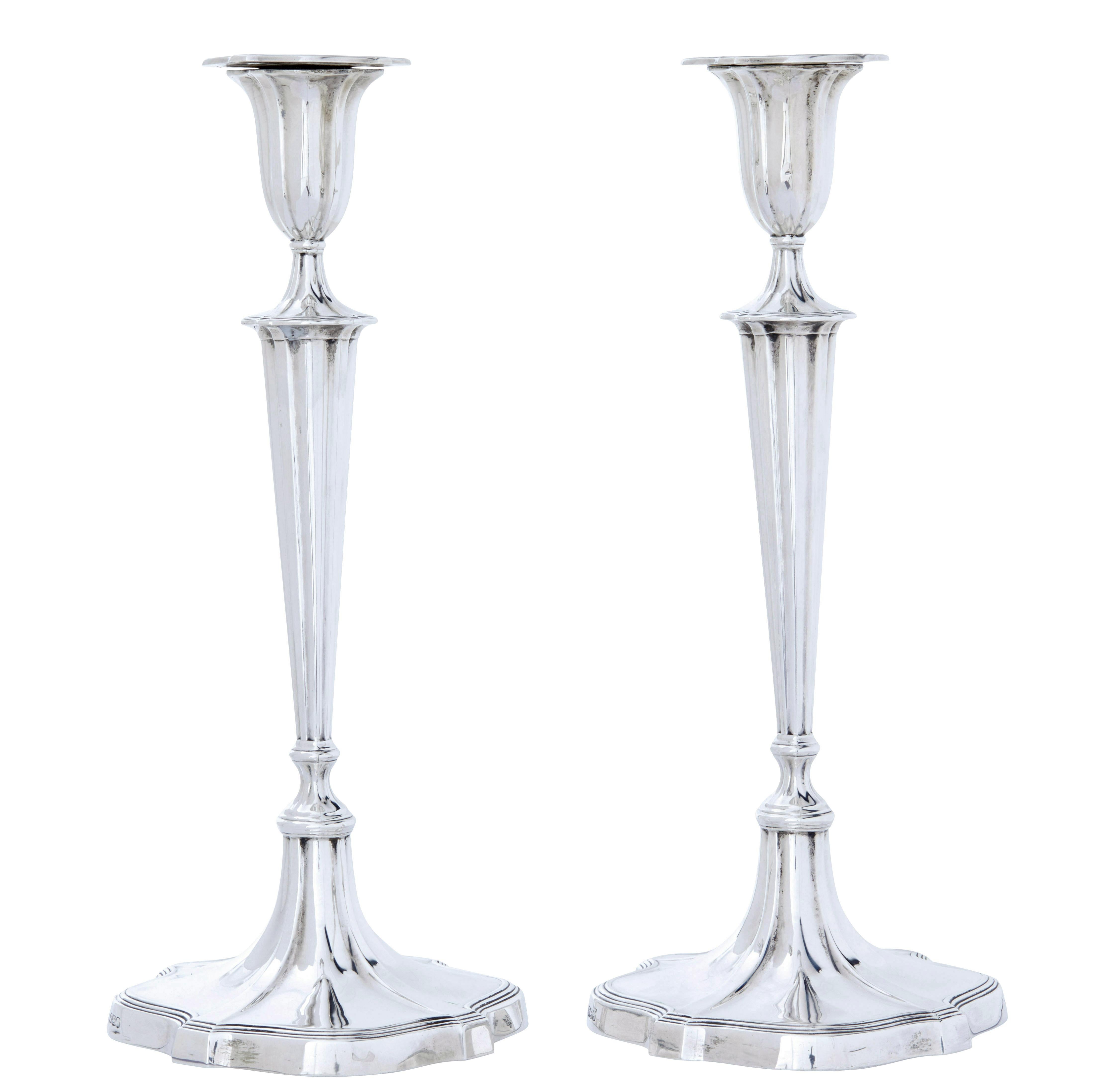 Coppia di candelieri in argento sterling dell'inizio del XX secolo, circa 1922.

Elegante coppia di candelieri da tavolo, con piani rimovibili stampati.  Steli scanalati e affusolati, in piedi su una base sagomata.

Stampigliato sul fondo Ryrie bros