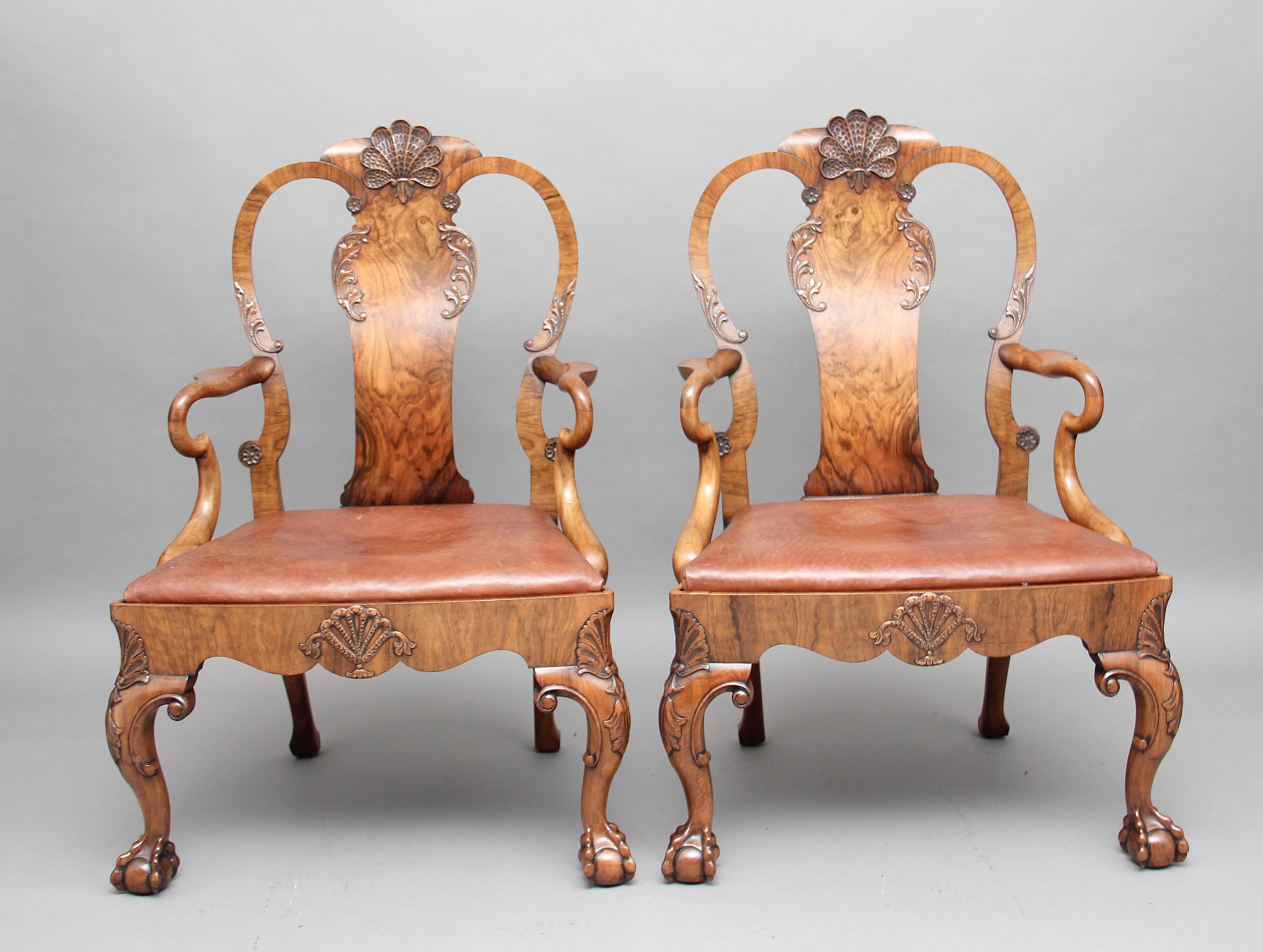 A superb pair of early 20th century walnut armchairs in the early Georgian style, the shaped splat back with a carved scallop shell and foliate decoration, with lovely sweeping shepherds crook arms and tan leather seats and shaped seat rails,