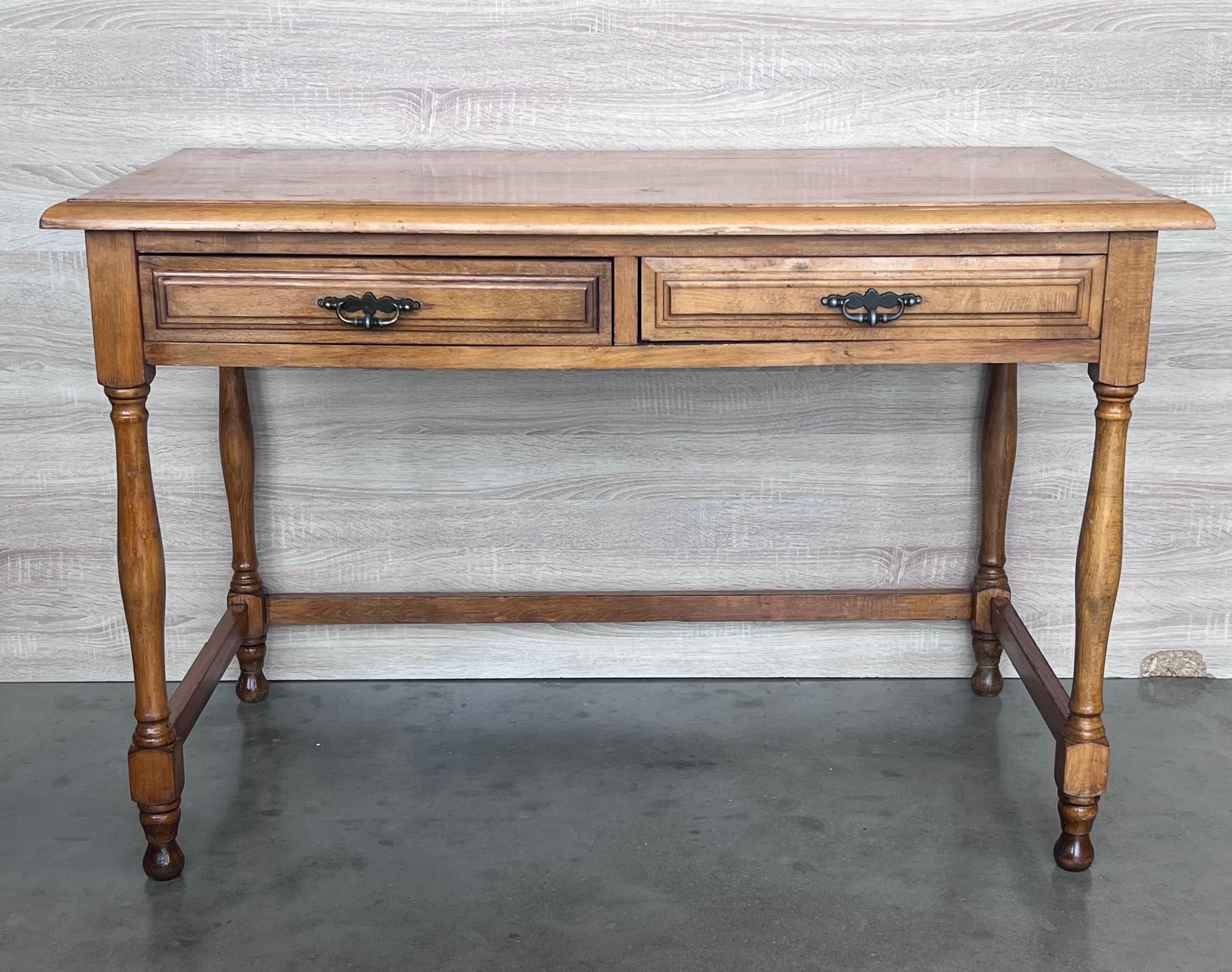 A charming early 20th century Spanish pine farm table with four legs and back side trestle and a wonderfully well-worn finish from a century of use. 

Height from to the drawers : 23.81in