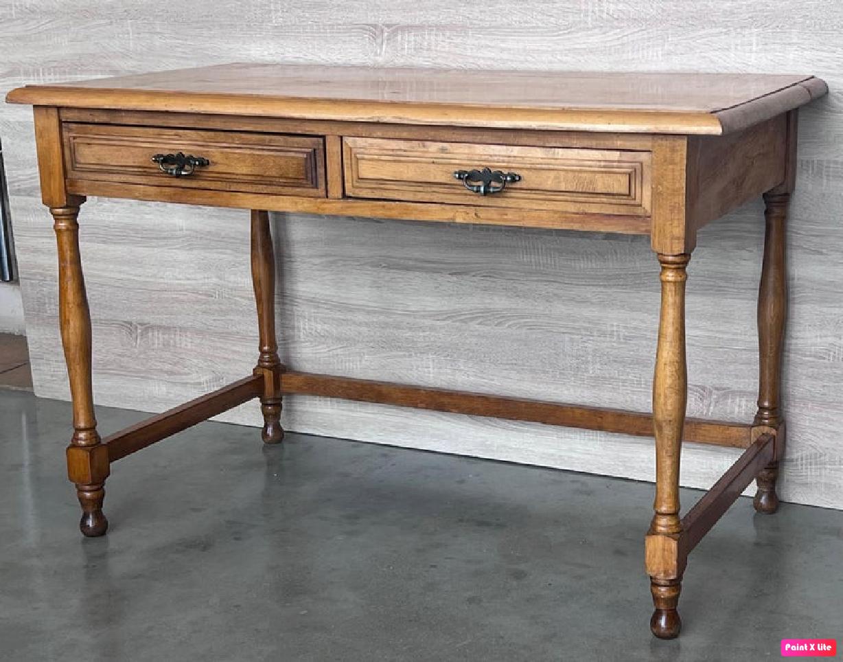 Charmante table de ferme en pin espagnol du début du 20e siècle, avec quatre pieds et un tréteau latéral à l'arrière, et une finition merveilleusement bien usée par un siècle d'utilisation. 

Hauteur des tiroirs : 23.81in