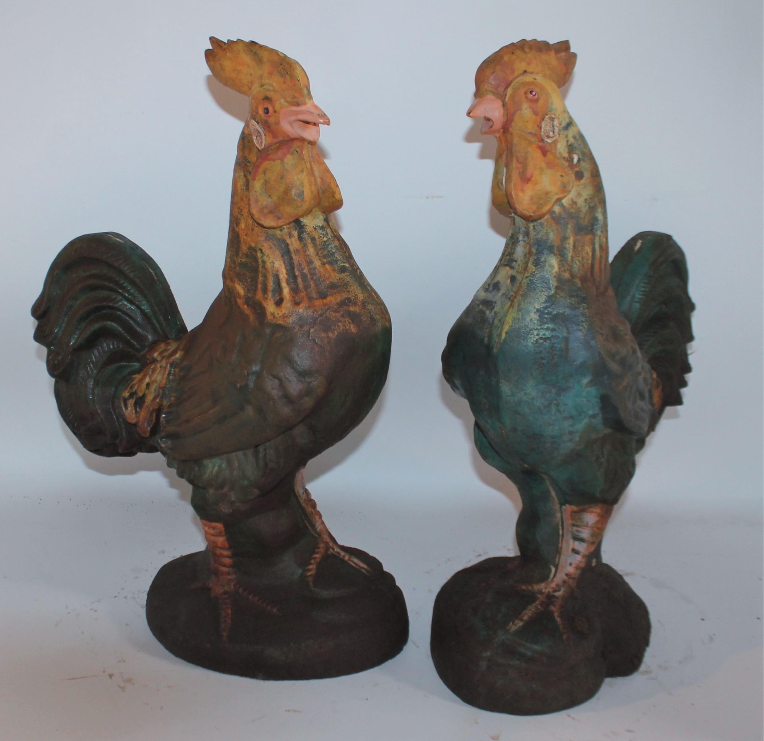 Pair of 20th century iron garden ornaments in original paint. Decorative and have great patina. These are heavy iron roosters.