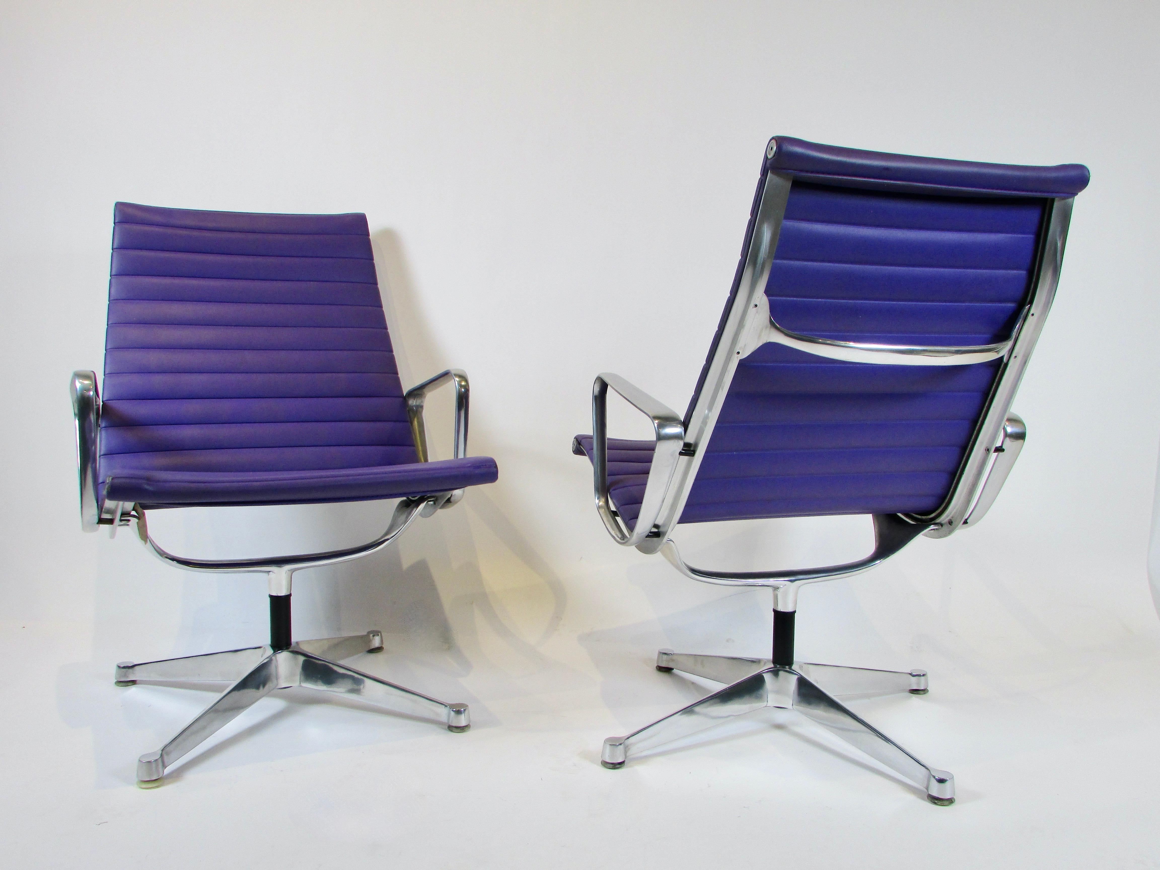 Pair of high back swivel Aluminum group chairs. These are of earlier production with the flat aluminum base. Original purple naugahyde covers are in very good to excellent condition. Ever so slight wear shows at leading edge corners. 
Part of the