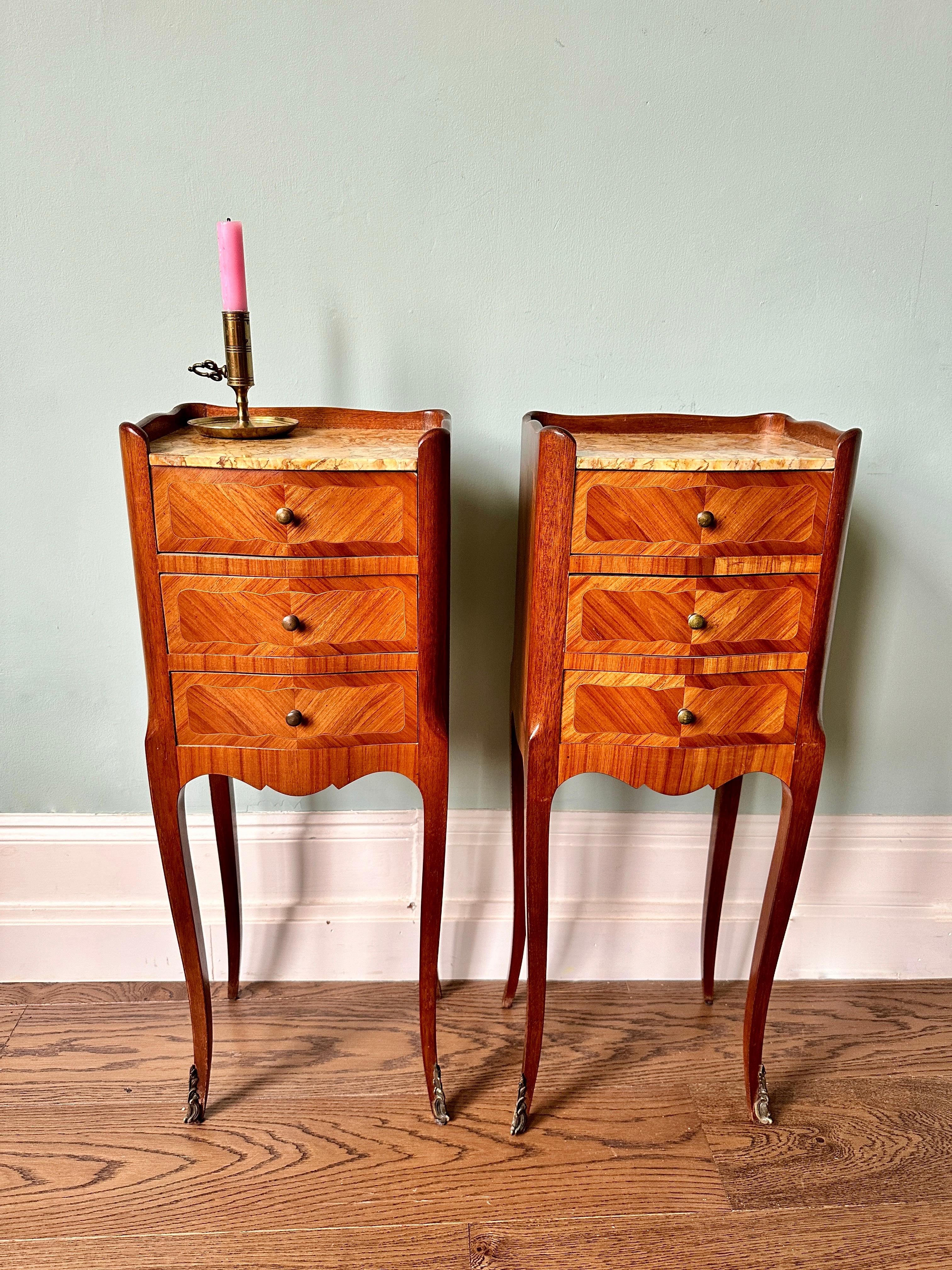 Pair of early C20th French kingwood veneer, mahogany and marble bedside tables.

Very elegant and slim Louis XVI style, three-drawer cabinets (circa 1910) raised on slender cabriole legs with brass handles and ormolu feet. 

In excellent and sturdy