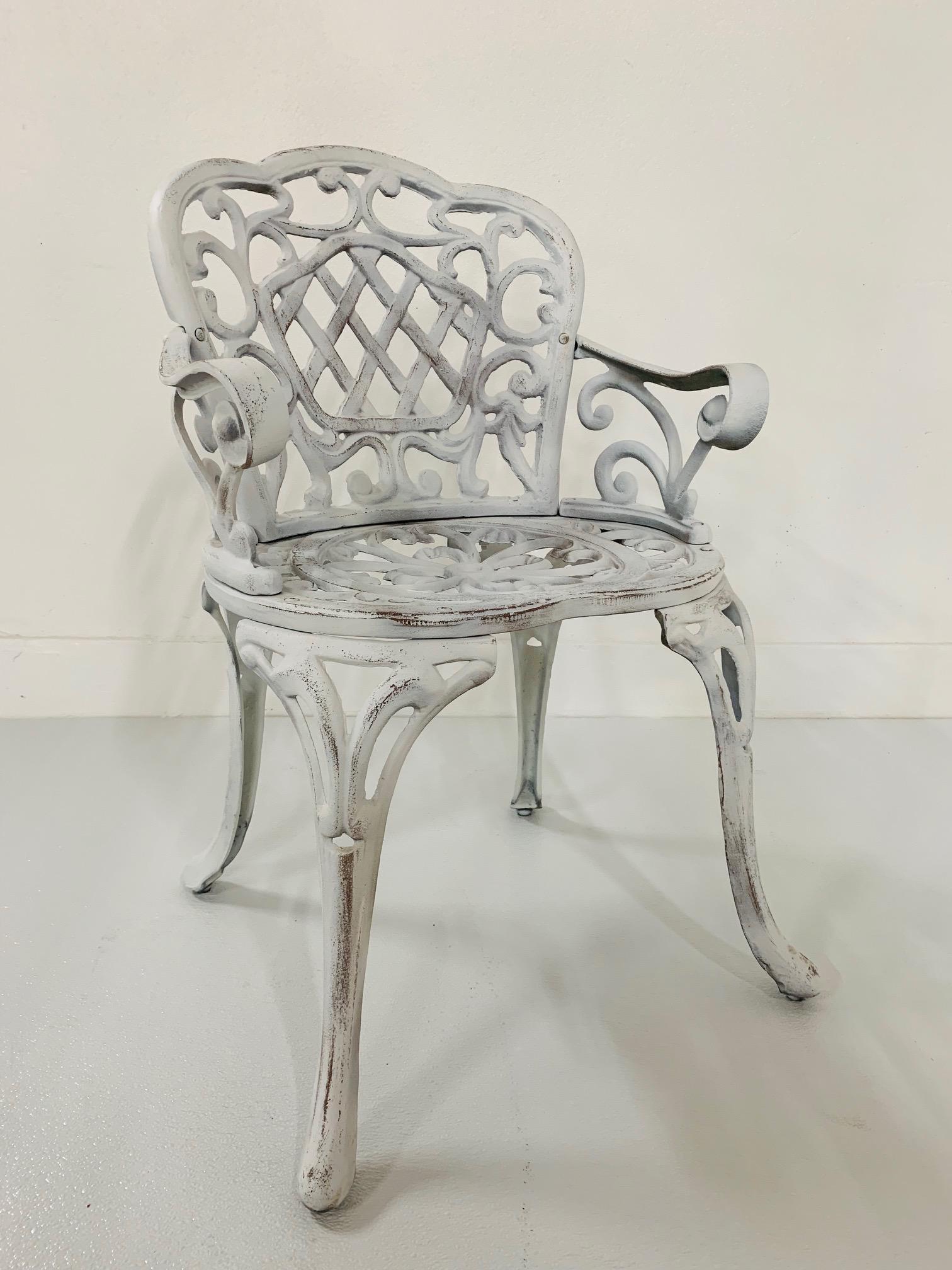 Pair of early cast iron garden armchairs. Painted white finish with a decorative pattern.