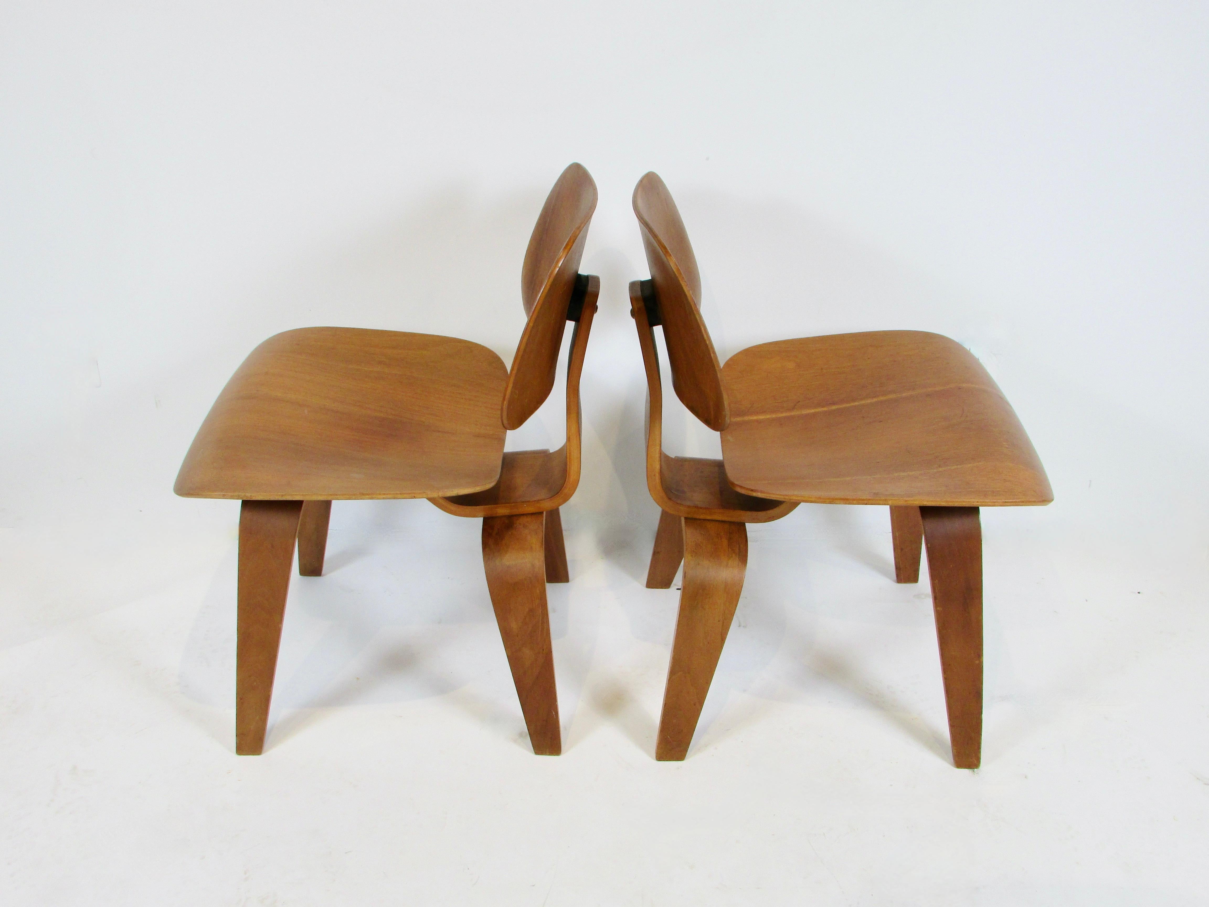 Pair of early Eames Evans Herman Miller walnut DCW chairs with labels 2