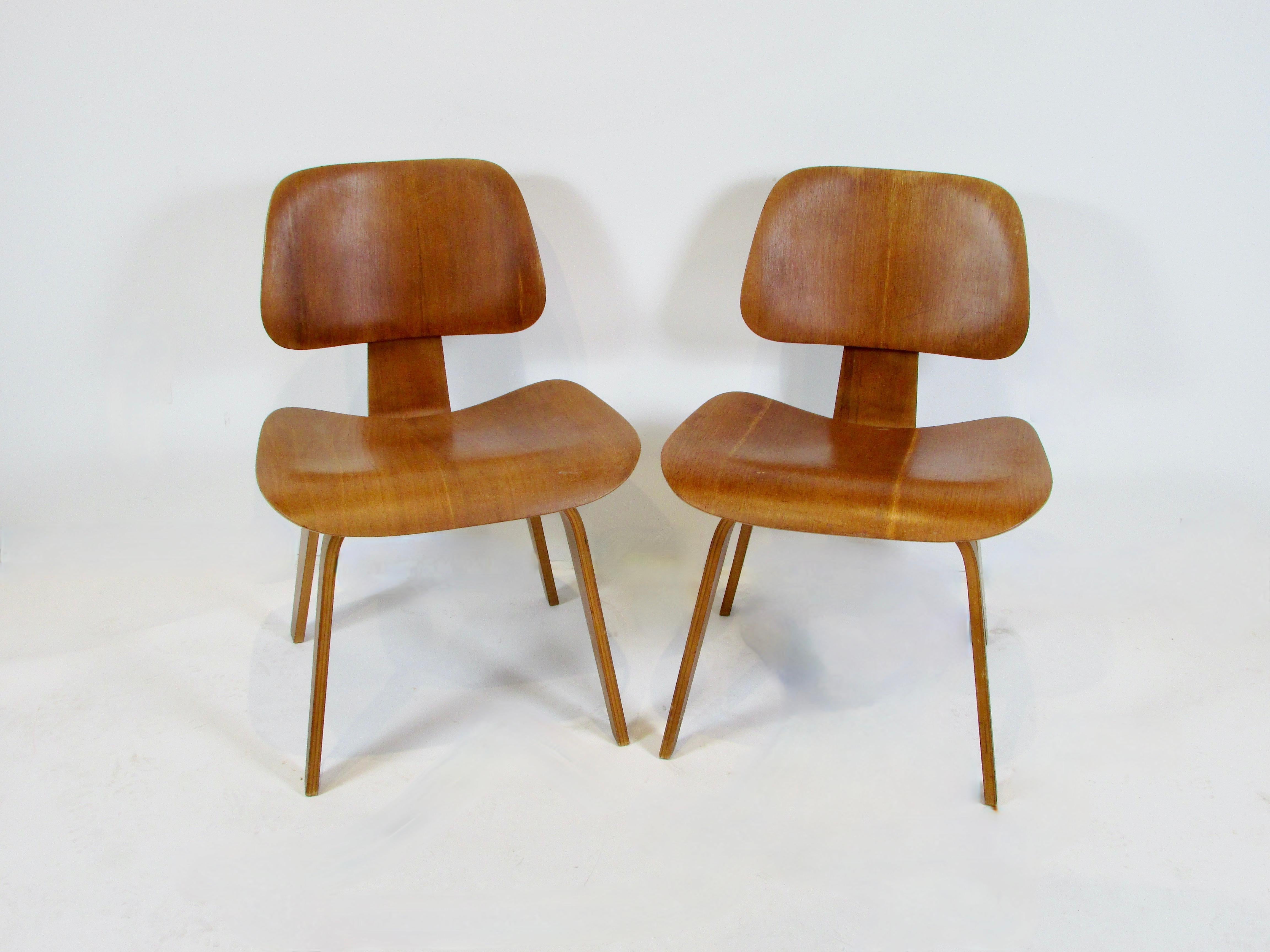 Does not get more Mid Century American Modern than this . Pair of earlier production maybe second generation Eames office DCW chairs . That is dining chair wood ( legs ) DCW . Completely original showing a lifetime of cared for use and patina . Both