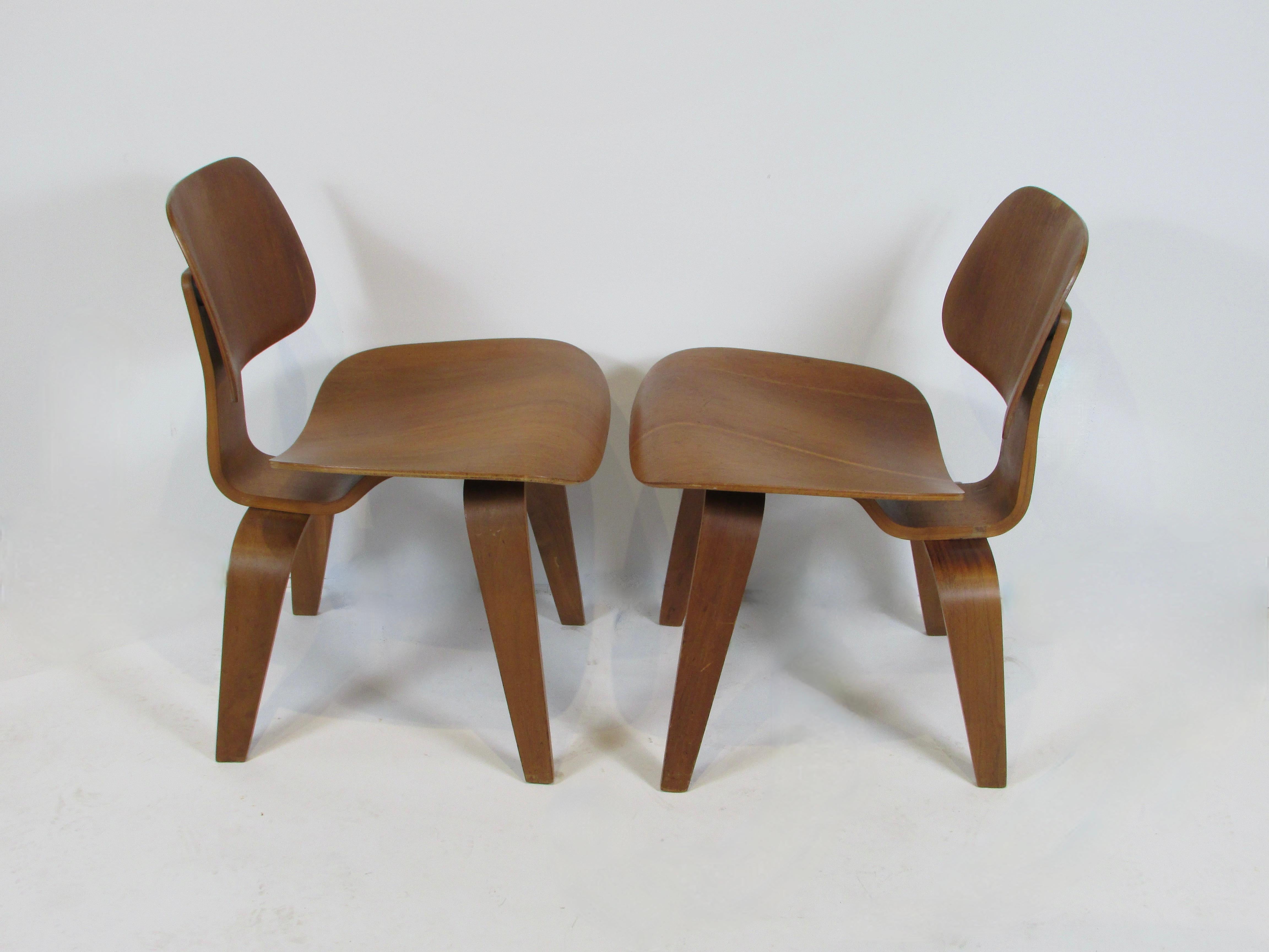 American Pair of early Eames Evans Herman Miller walnut DCW chairs with labels