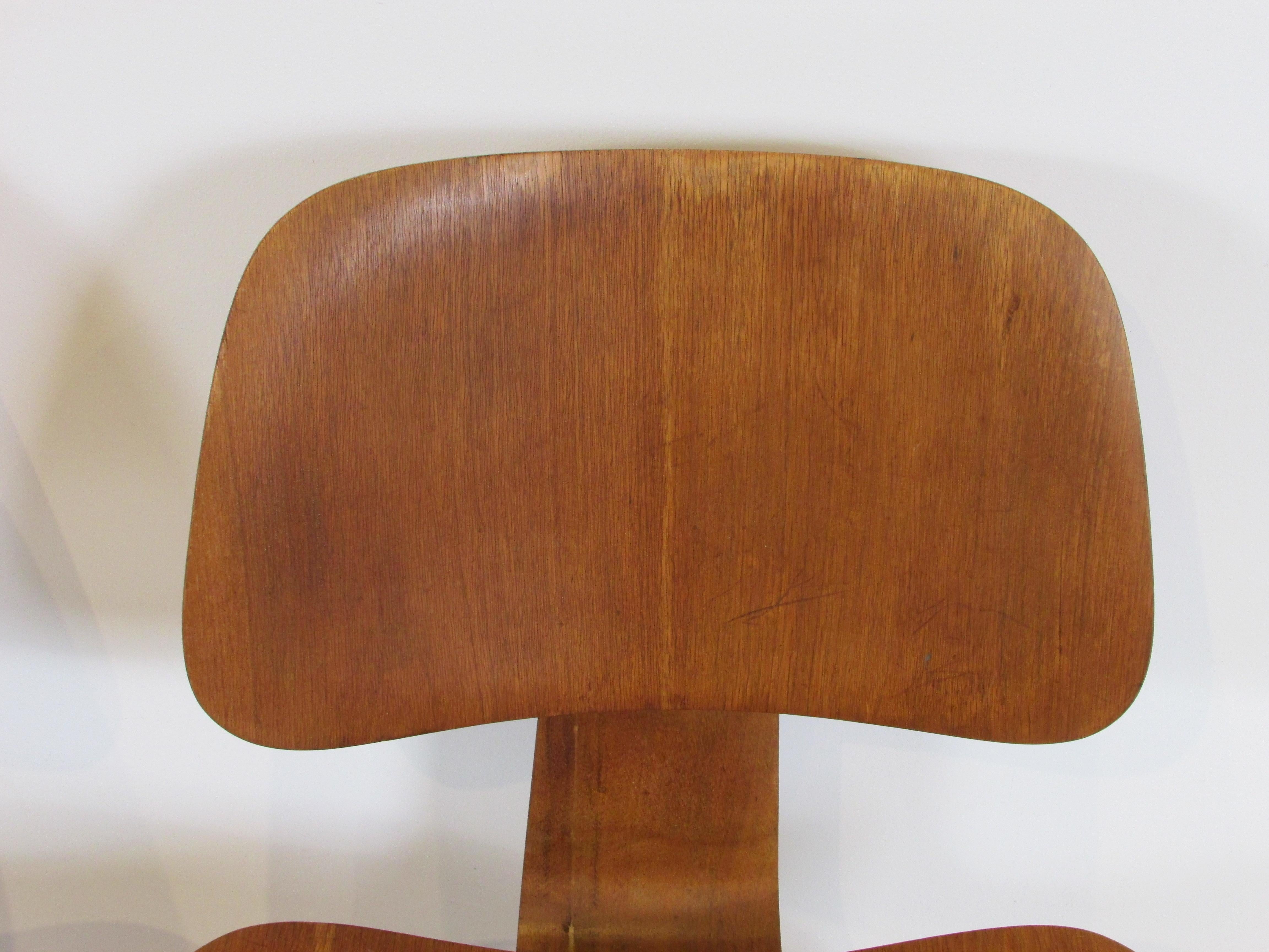 Pair of early Eames Evans Herman Miller walnut DCW chairs with labels For Sale 1