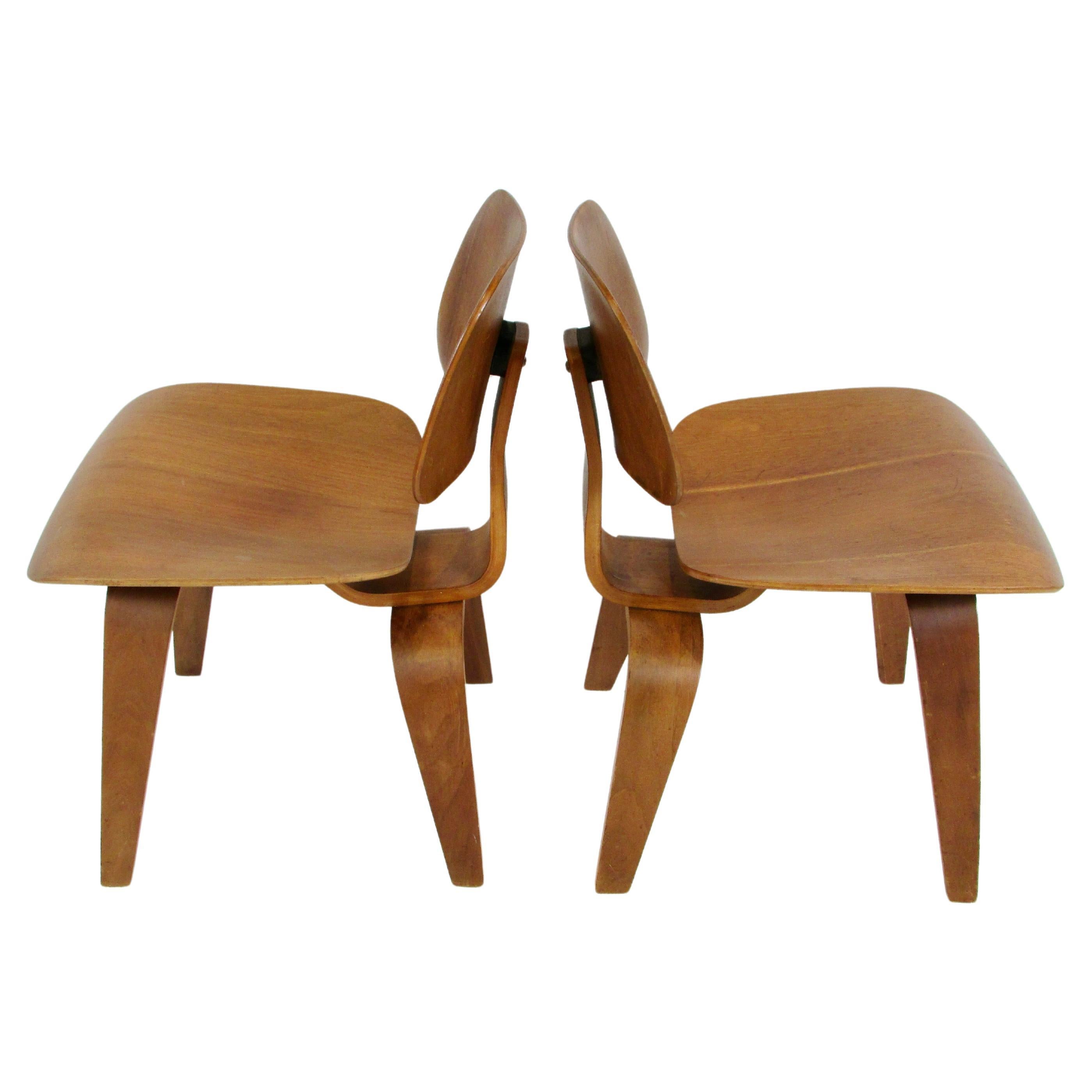 Pair of early Eames Evans Herman Miller walnut DCW chairs with labels For Sale
