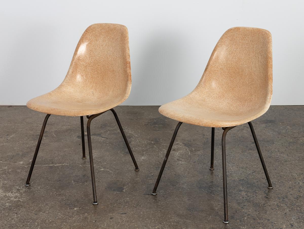 Original 1960s molded fiberglass shell chairs in thready tan, designed by Charles and Ray Eames for Herman Miller. Gleaming shells are in original condition, in a lovely tan hue with an outstanding thready texture. Mounted on vintage black H base,