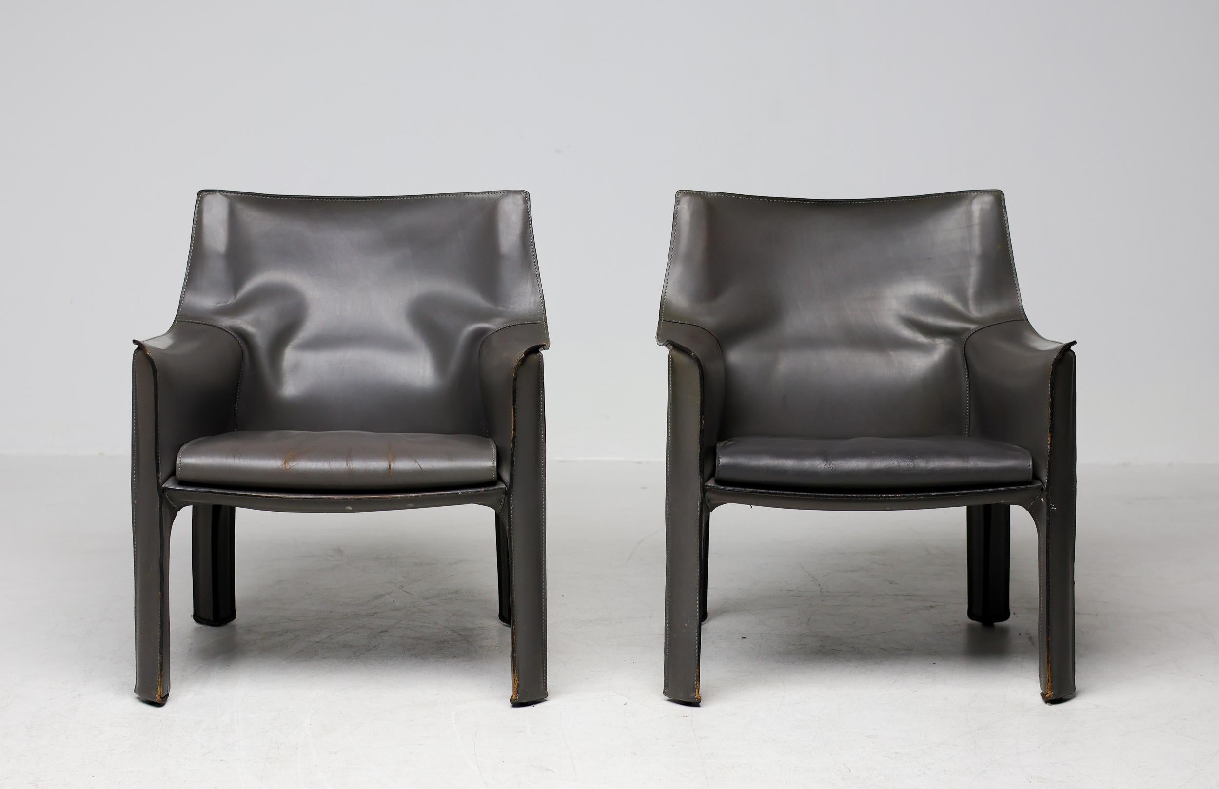 Pair of very early Mario Bellini Cab 414 arm chairs made by Cassina, with elephant hide grey saddle leather upholstery zippered over the steel frame. Many years of careful use gave them that unmistakable vintage appearance of a pair of used leather