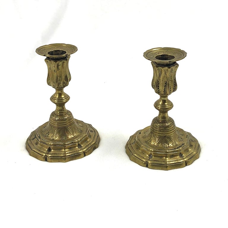 An unusual pair of French Louis XV engraved low candlesticks with removable bobeches and delicately incised and decorated bases. Also, having original silvering under the base.