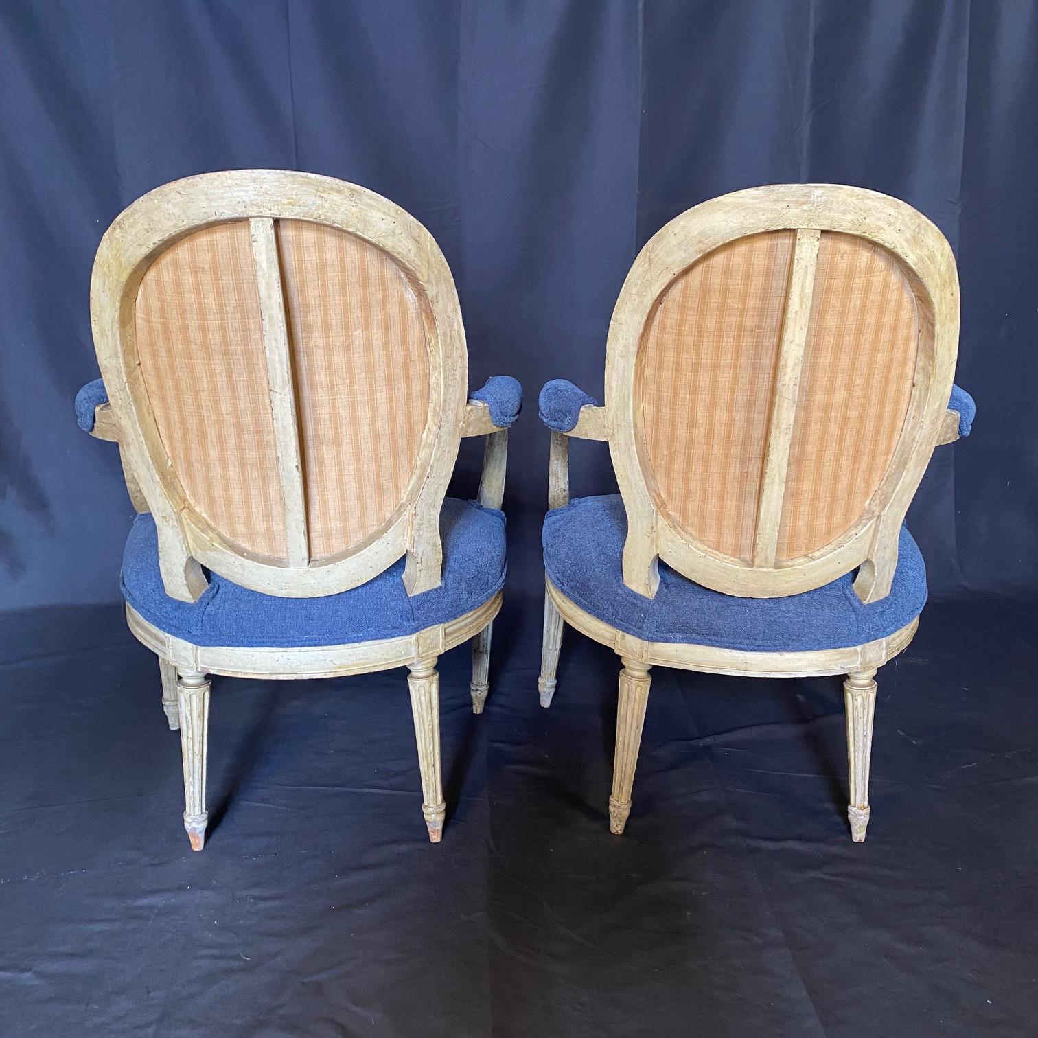 Beautiful colors in this showstopping pair of Louis XVI armchairs or fauteuils, in their original paint, with Aubusson tapestry on their back depicting figures and animals with stunning detail and lovely blue color! Complementary to the tapestry,