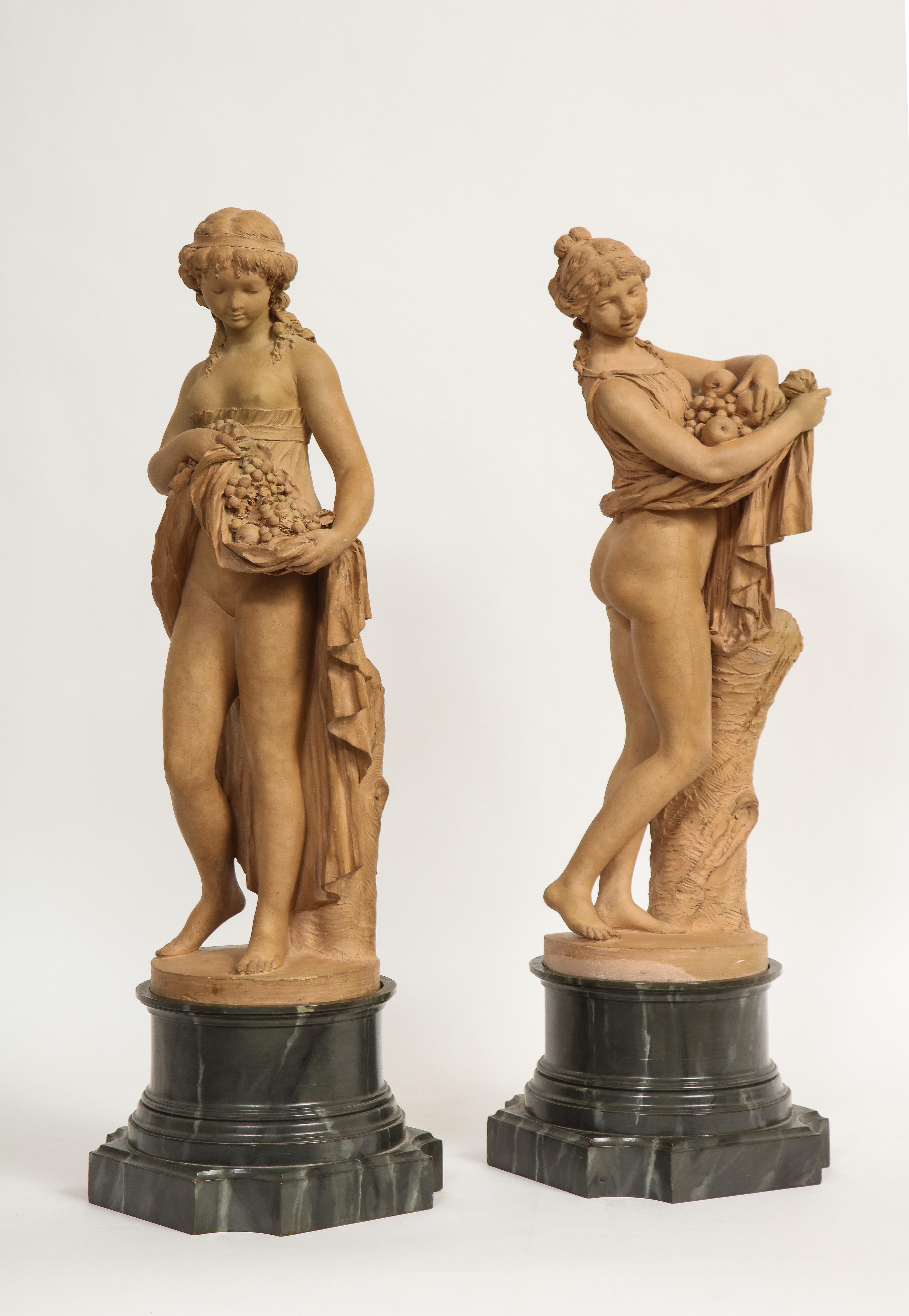 Une fantastique paire de figures en terre cuite française du 18e/19e siècle représentant Pomone et une jeune fille portant des fruits dans sa jupe, signées Clodion. Ces exceptionnelles figures en terre cuite représentant deux belles femmes sont