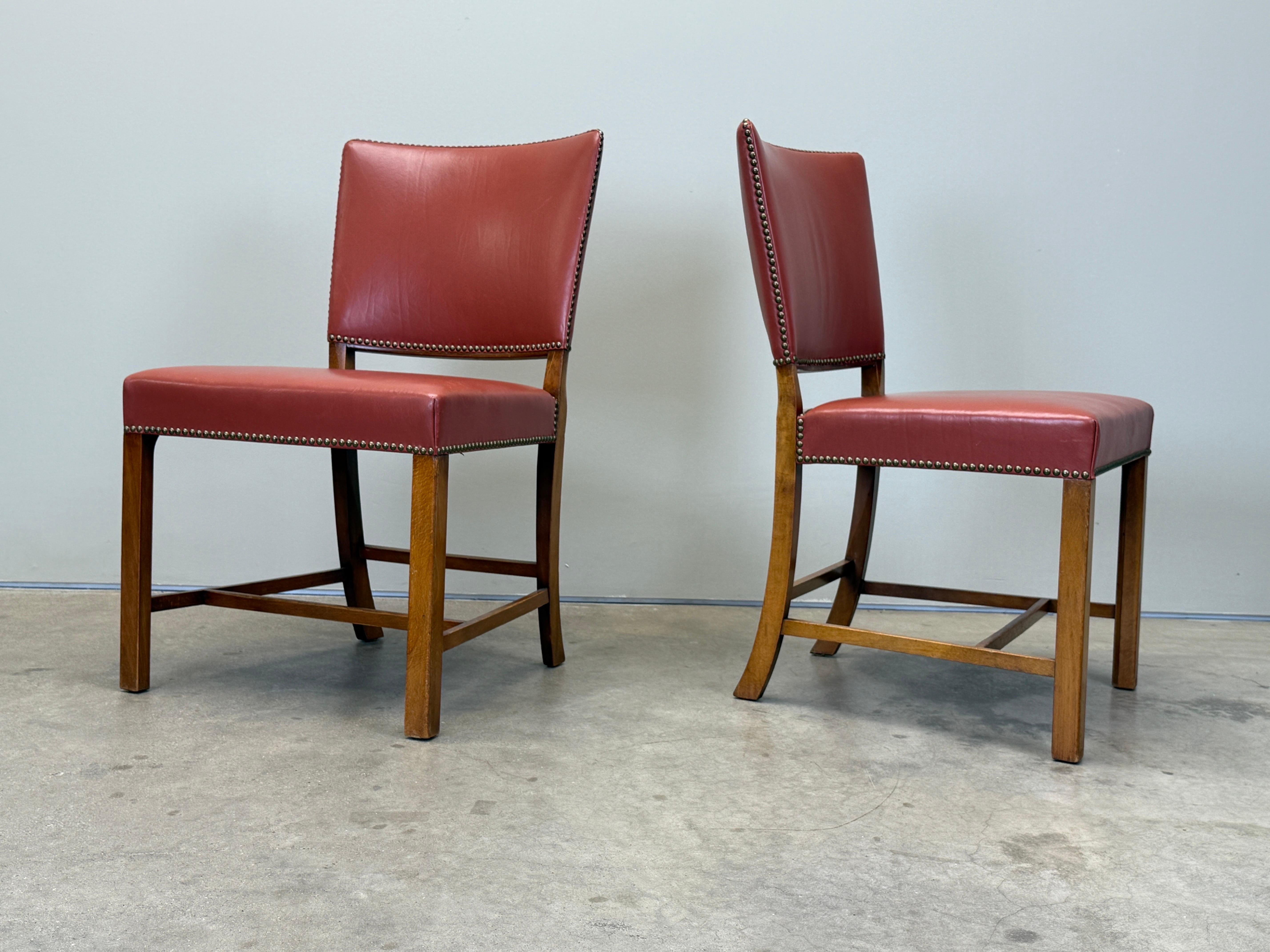 Une paire de chaises de salle à manger Fritz Hansen est en cuir d'origine de couleur saumon. Très similaire à la Red Chair de Kaare Klint. 