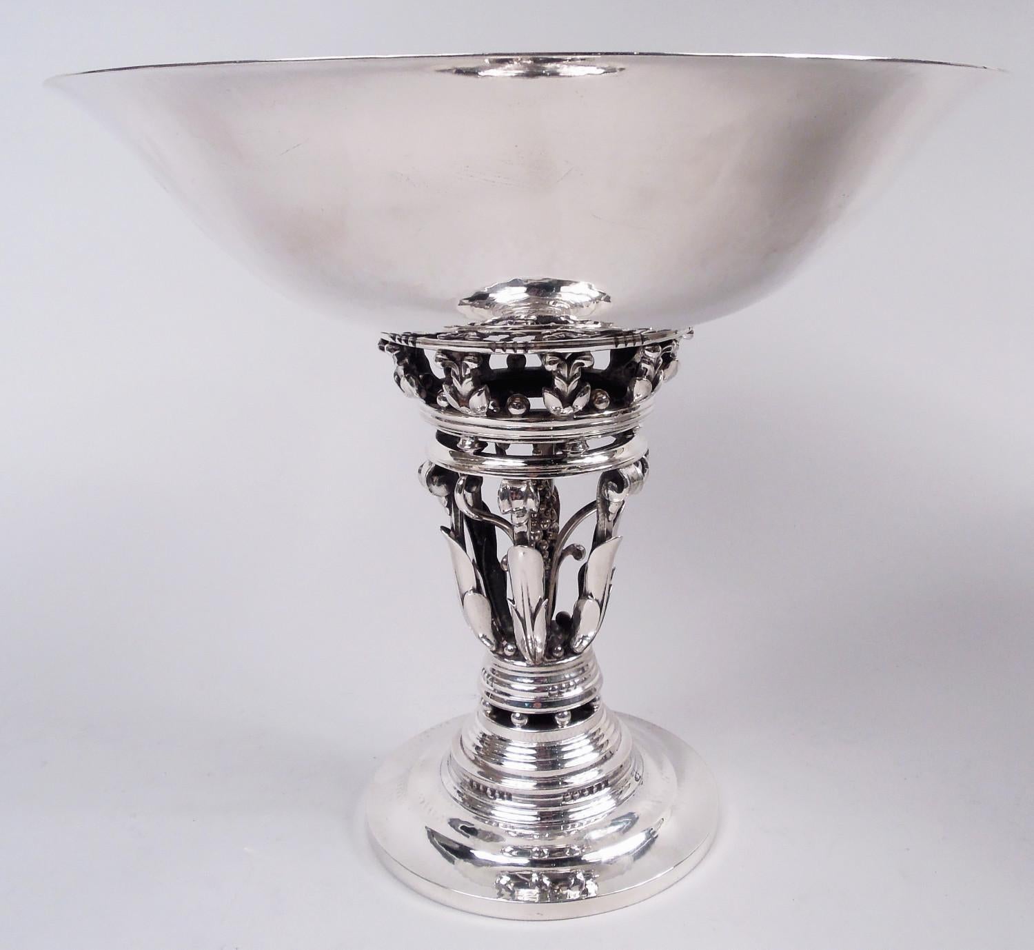 Coppia di composte moderne danesi in argento sterling. Prodotto da Georg Jensen a Copenhagen. Ciascuno: Ciotola ampia e ricurva e piede a gradini. Fusto aperto a forma di foglie e volute imbricate che circondano il baccello centrale. Motivi