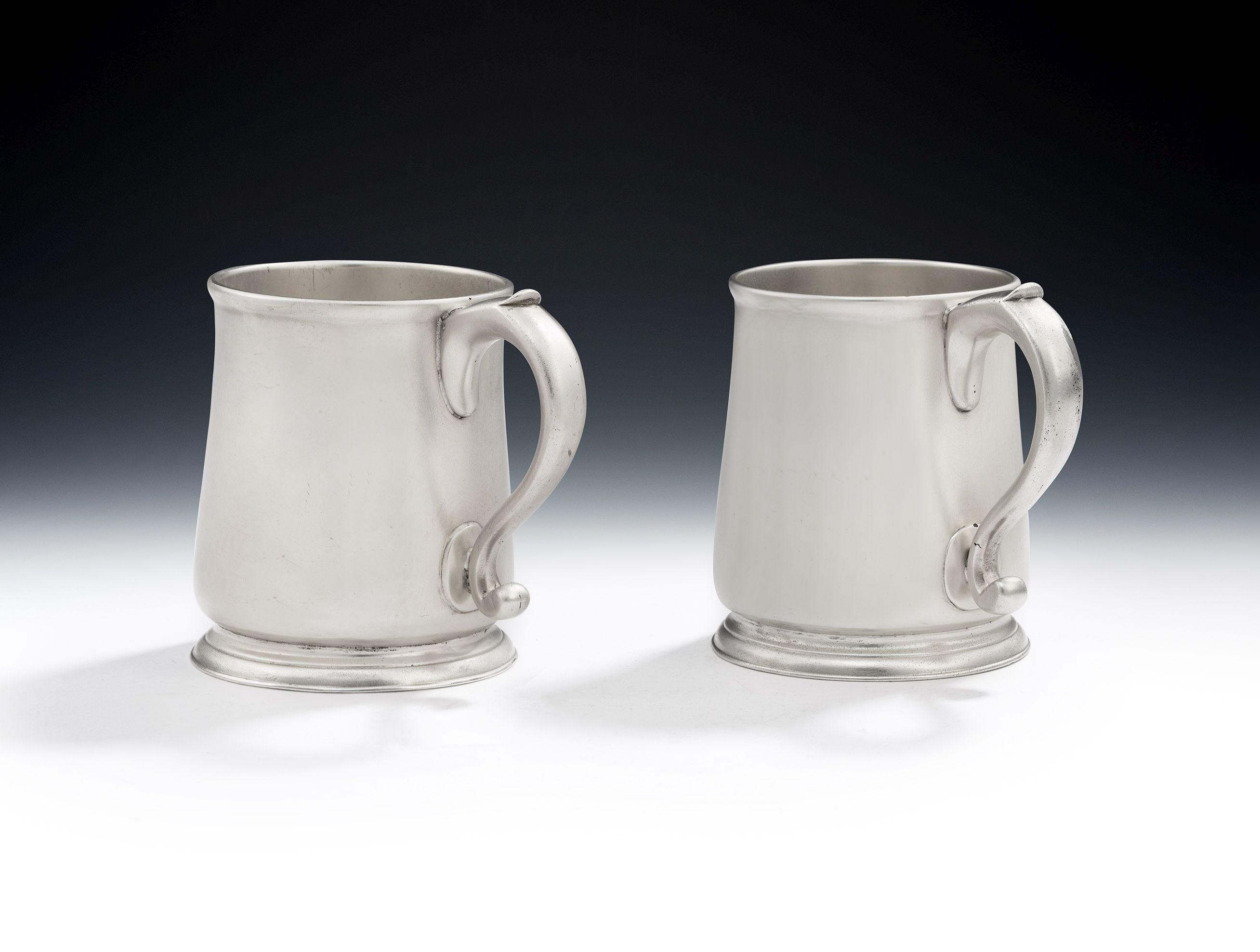 A very fine pair of early George III Mugs made in London in 1764 by Thomas Whipham II & Charles Wright.

The Mugs stand on an applied circular foot decorated with reeding. The slightly tapering sides have an everted rim and 