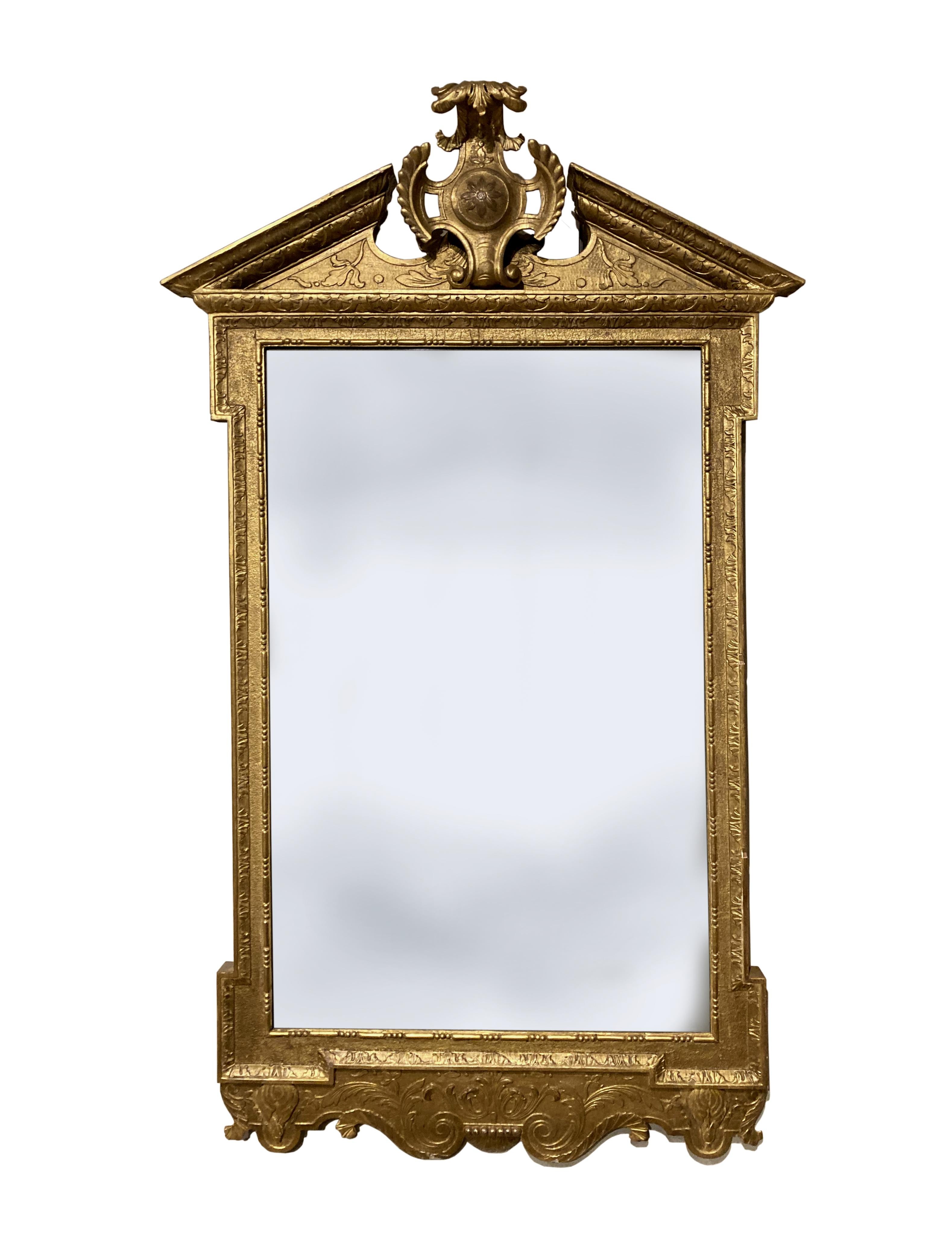 A rare pair of early Georgian cut gesso mirrors mainly in their original gilt; the plates look original but were probably replaced some time ago; a finely carved cartouche in the centre of the broken pediment.
