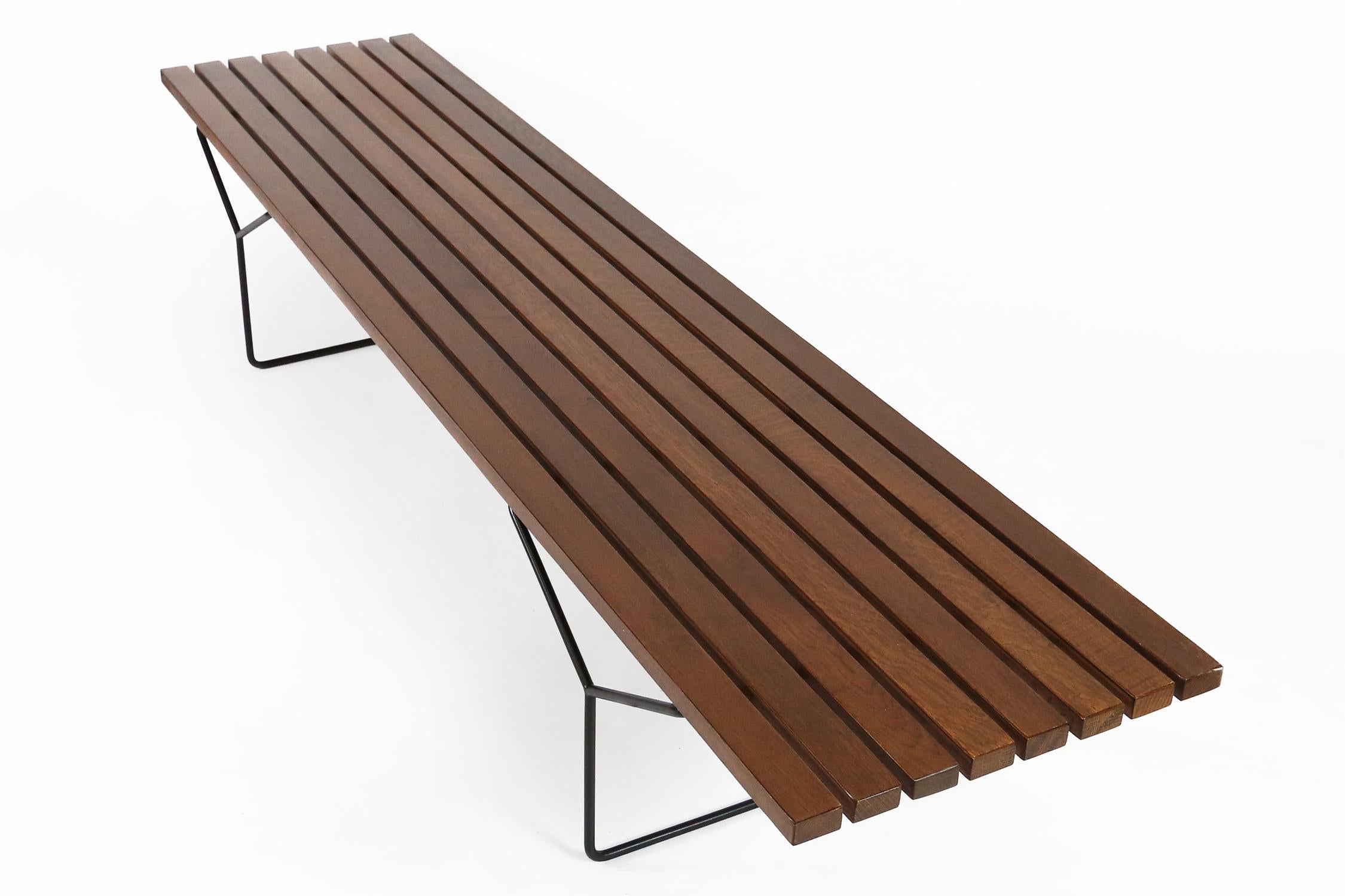 A great pair of early Harry Bertoia designed wood slat benches for Knoll International, made in Belgium by De Coene under license of Knoll International. The wood slats been refinished on both benches and they still have their original metal