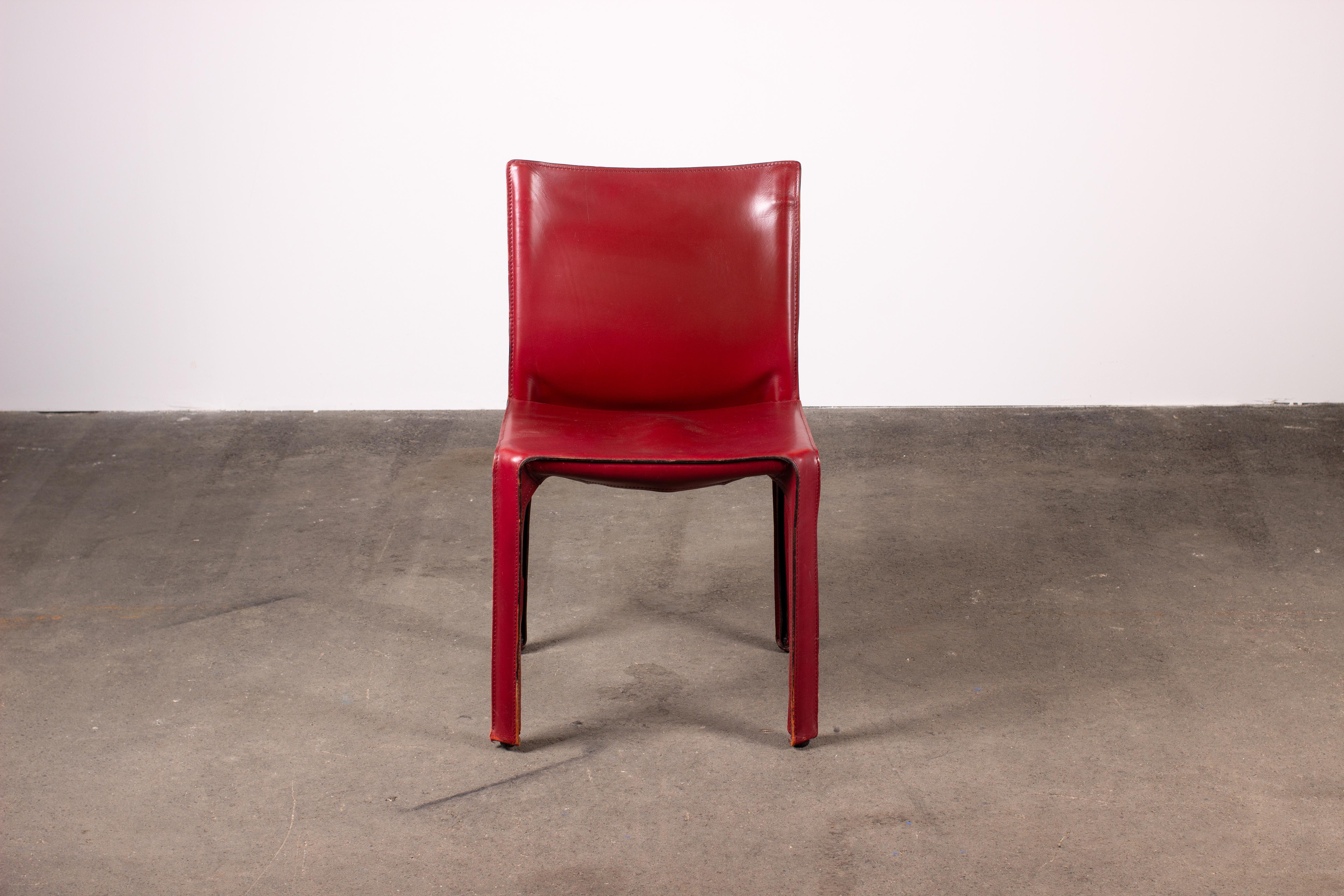Set of two Mario Bellini CAB 412 chairs, made by Cassina in the 1970s. Flexible steel frame covered with a skin of high quality burgundy red saddle leather. This elegant, versatile chair is equally suitable for the dining room, study or living room.