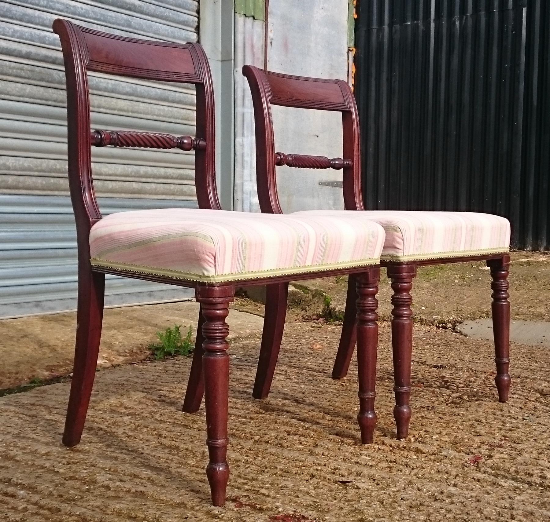 Pair of early 19th century mahogany antique dining chairs standing on turned legs with rope twist back bar. There is some Fine reeded decoration around the seat and on the back rails. 

English circa 1820 

Measures: 47cm / 18½