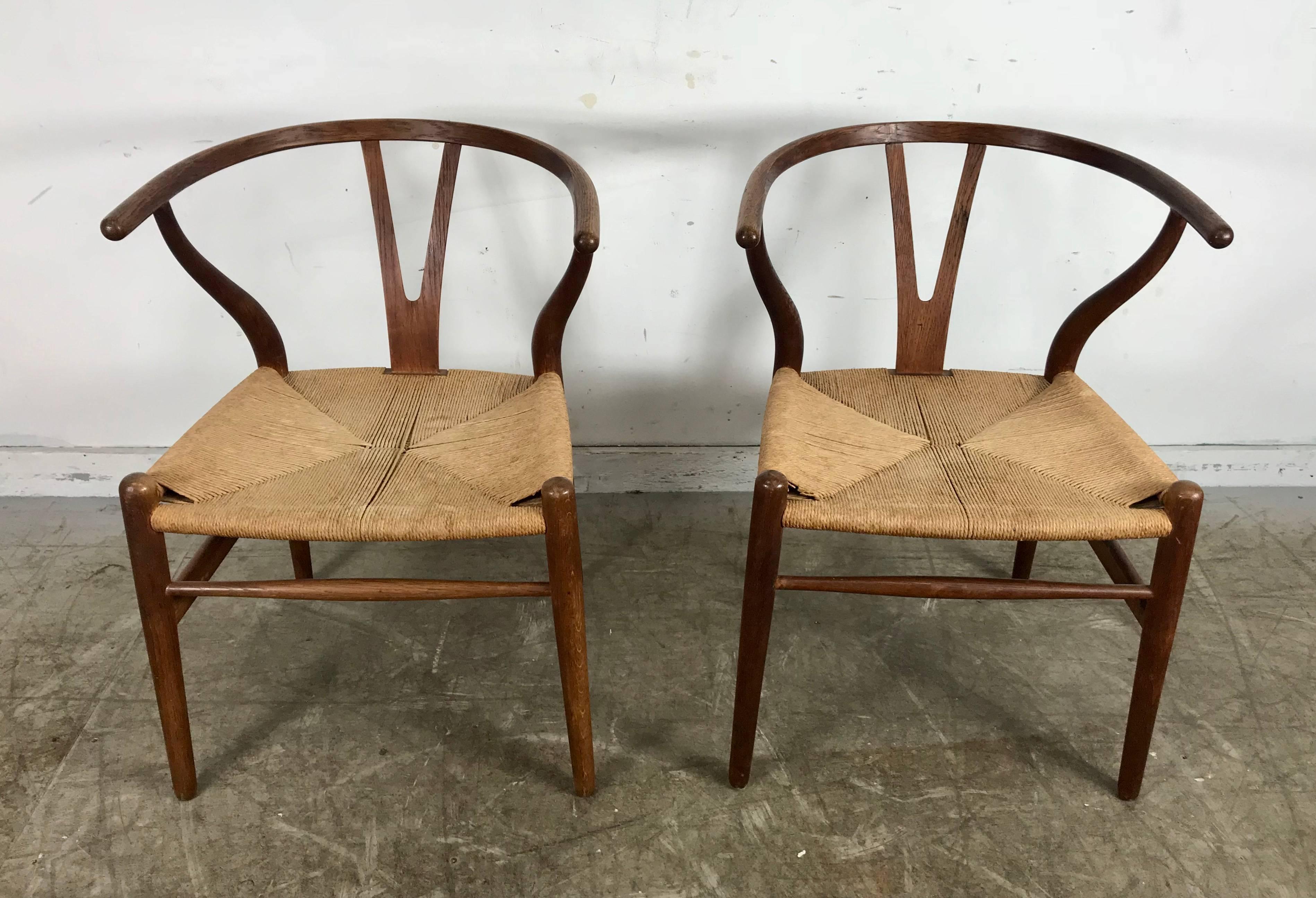 Early pair of Danish modern wishbone chairs CH24 in oak. Wonderful original condition, amazing color, surface and patina.