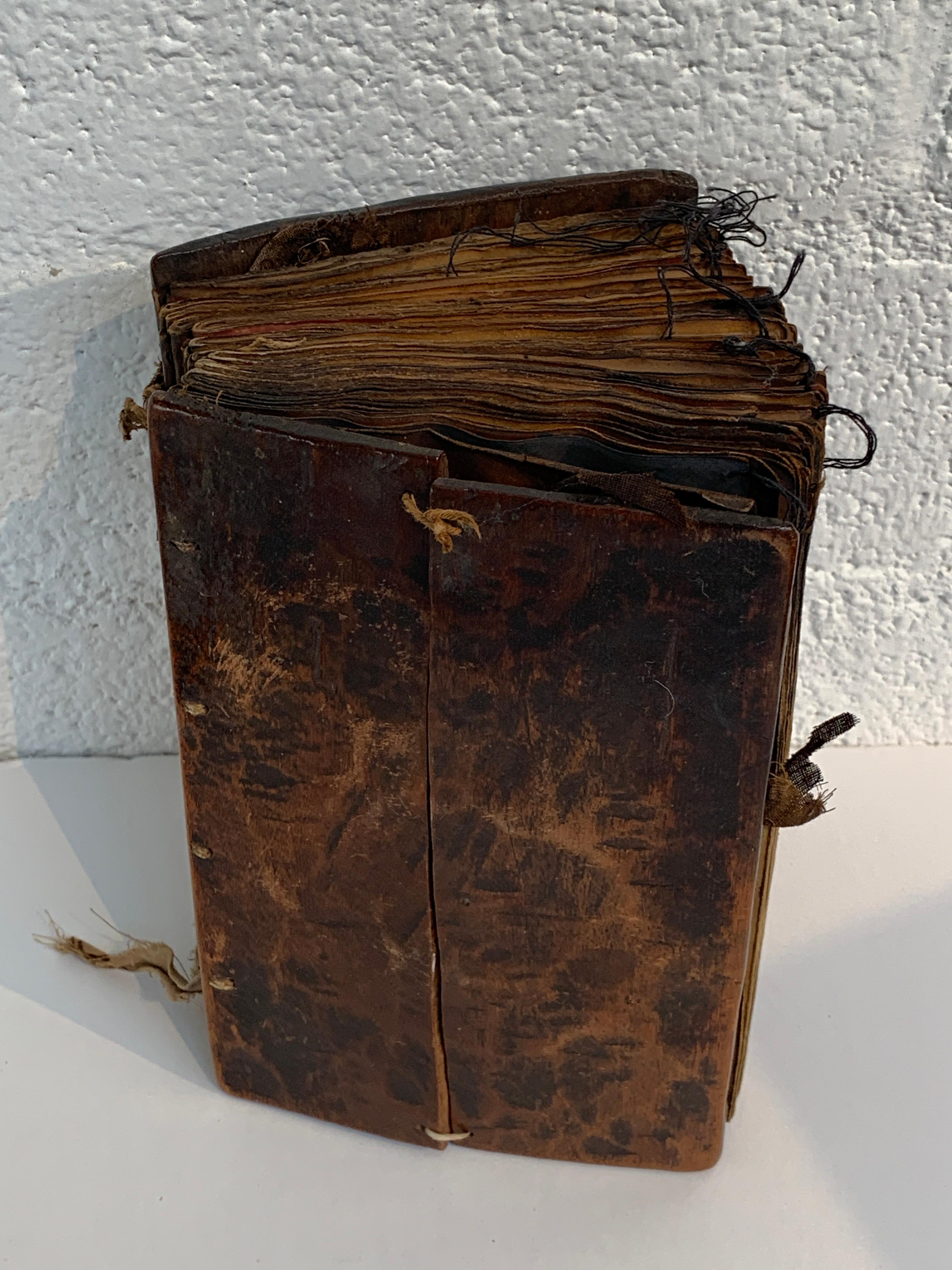 A beautiful pair of wood bound early Coptic Bibles or Religious books. They feature hand painted pages. These are old and worn with numerous age and use imperfections.