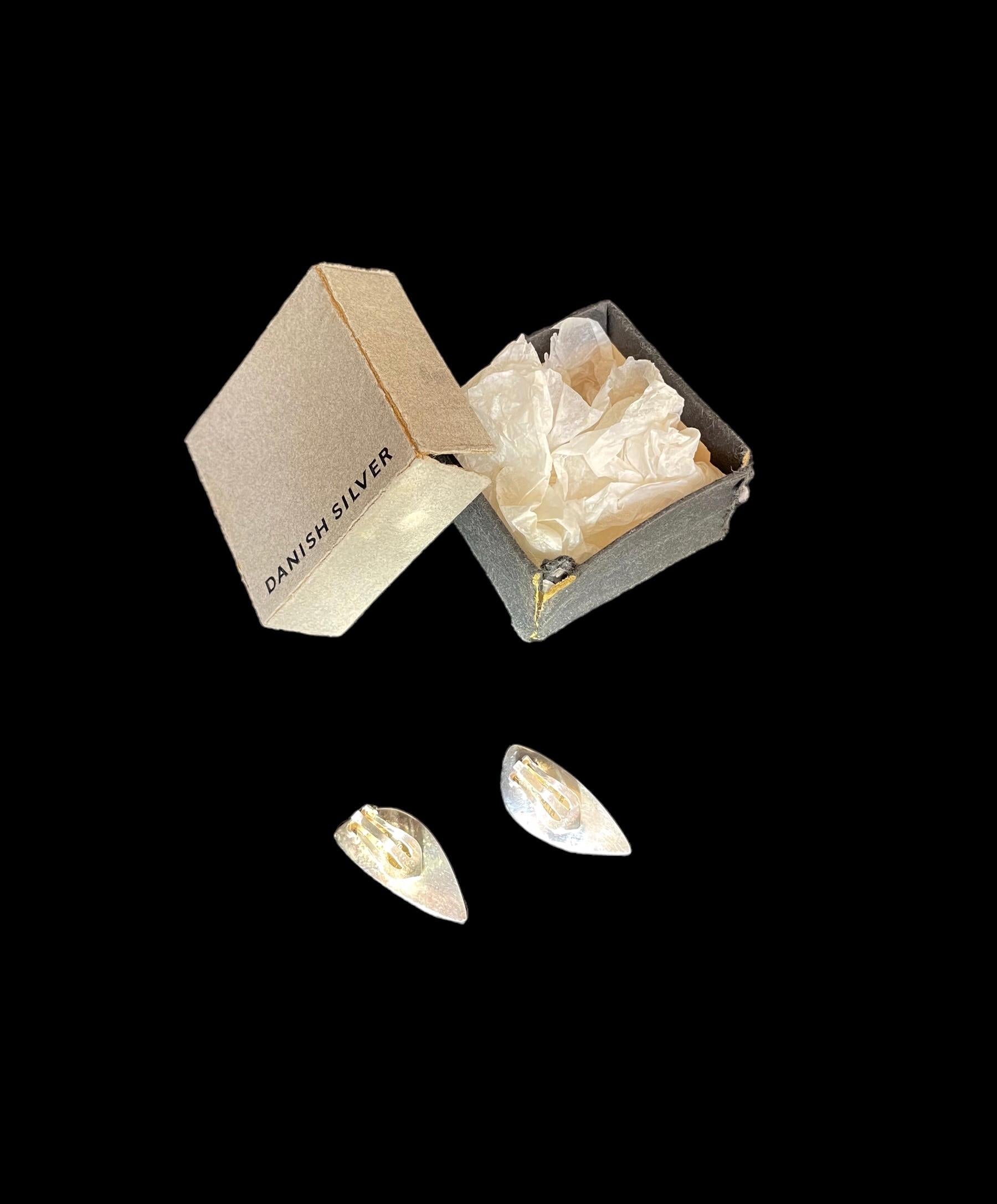 1960er Jahre Hans Hansen Silberohrringe, Dänemark 318 entworfen von Bent Gabrielsen (1928-2014).
Ein Paar modernistische Blatt-Ohrringe aus massivem Silber. 
Konkave Blattform mit abgeschrägter Kante und Clip-Beschlägen.

HANS HANSEN
Hans Hansen