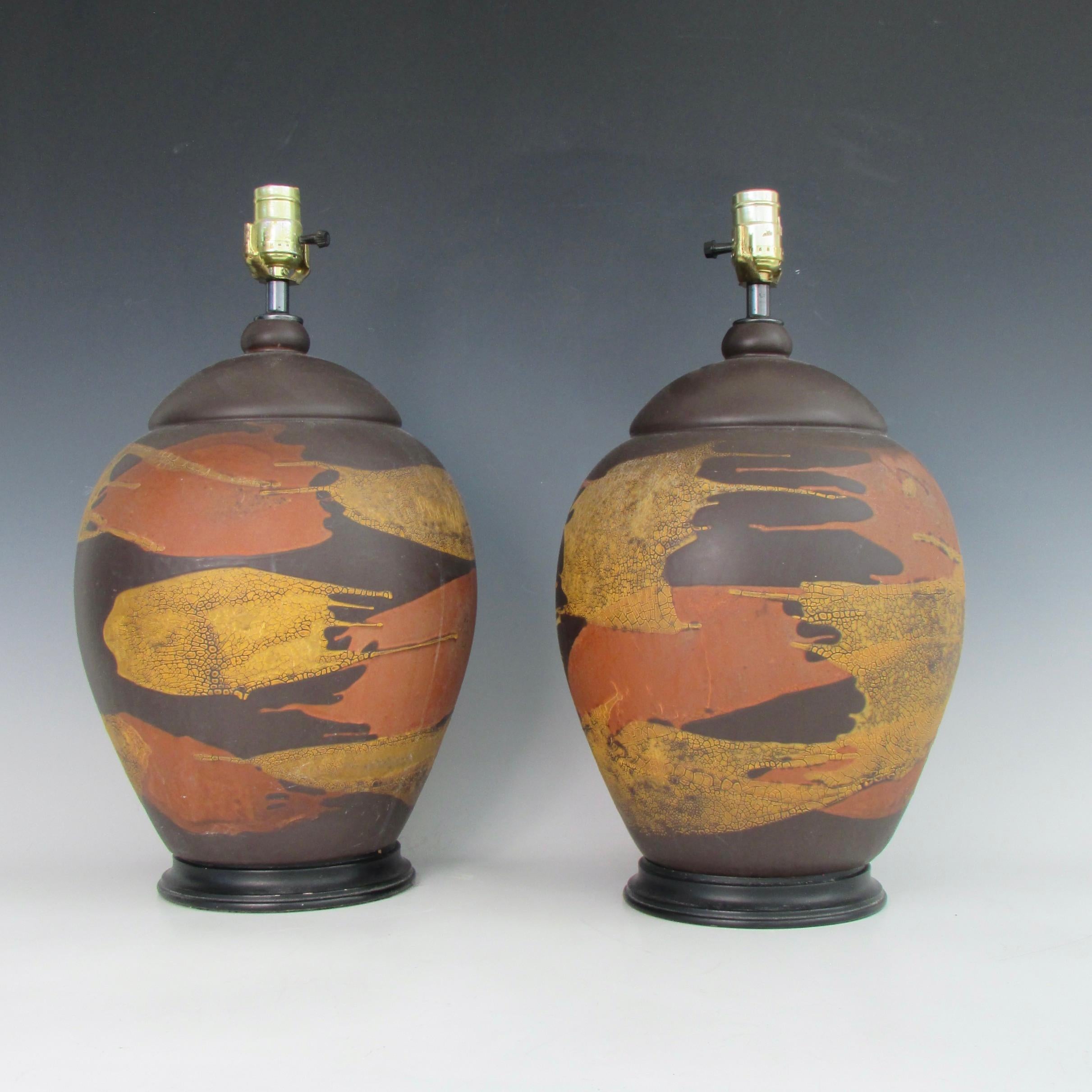 Pair of bulbous form table lamps. Fired in orange, brown, golden yellow autumn earth tones. Height measurement of 16