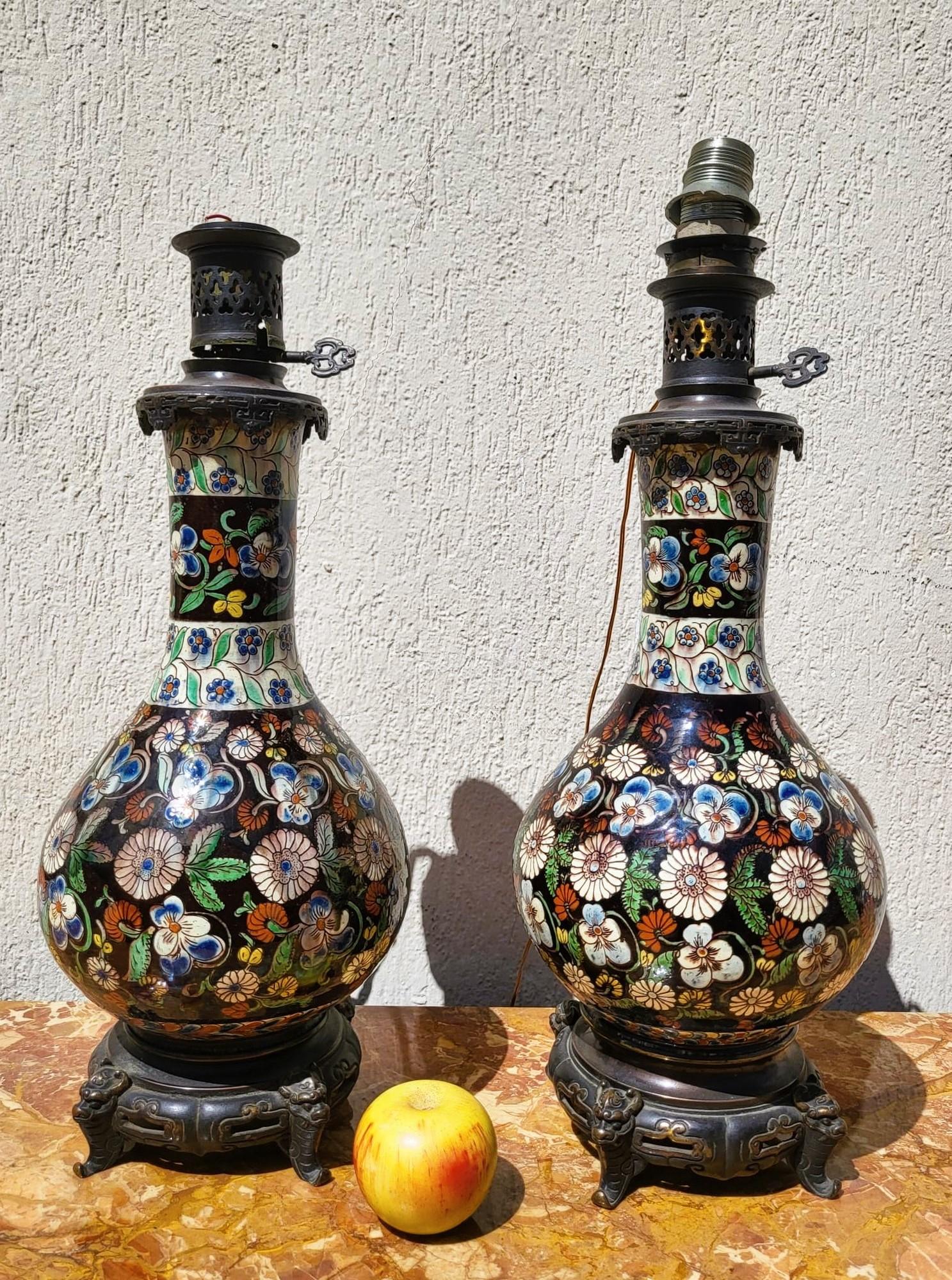 Pair of large earthenware lamps from Thun, decorated with flowers on a brown background and mounted on a bronze base in the Japanese style

An old restoration at one of the necks

Wear and tear, electricity to be reviewed (or done to US