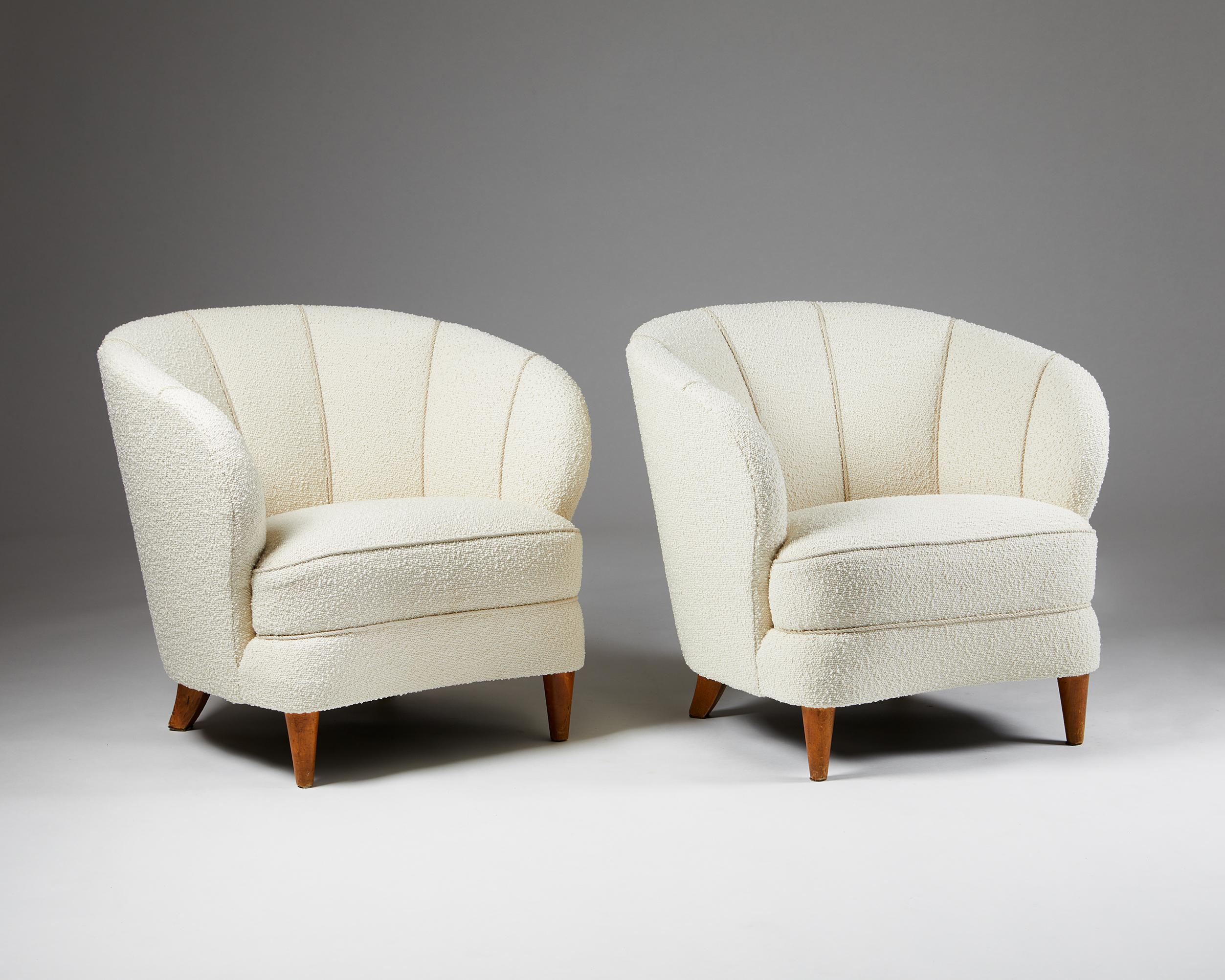Pair of easy chairs attributed to Carl-Johan Boman,
Finland, 1950s.
Lacquered wood and reupholstery in Boucle fabric.

These exclusive and extremely comfortable chairs have generous armrests and curved, encompassing shell-shaped backs. They are