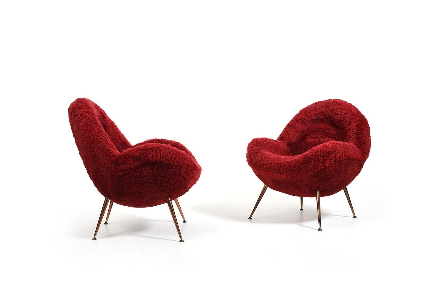 Paire de fauteuils / chaises longues Fritz Neth en laine d'agneau rouge / bordeaux d'origine. Modèle à pieds coniques en laiton conçu en 1955 pour Correcta. Le tout en état d'origine, avec la première sellerie. Produit dans les années 1950. Prix