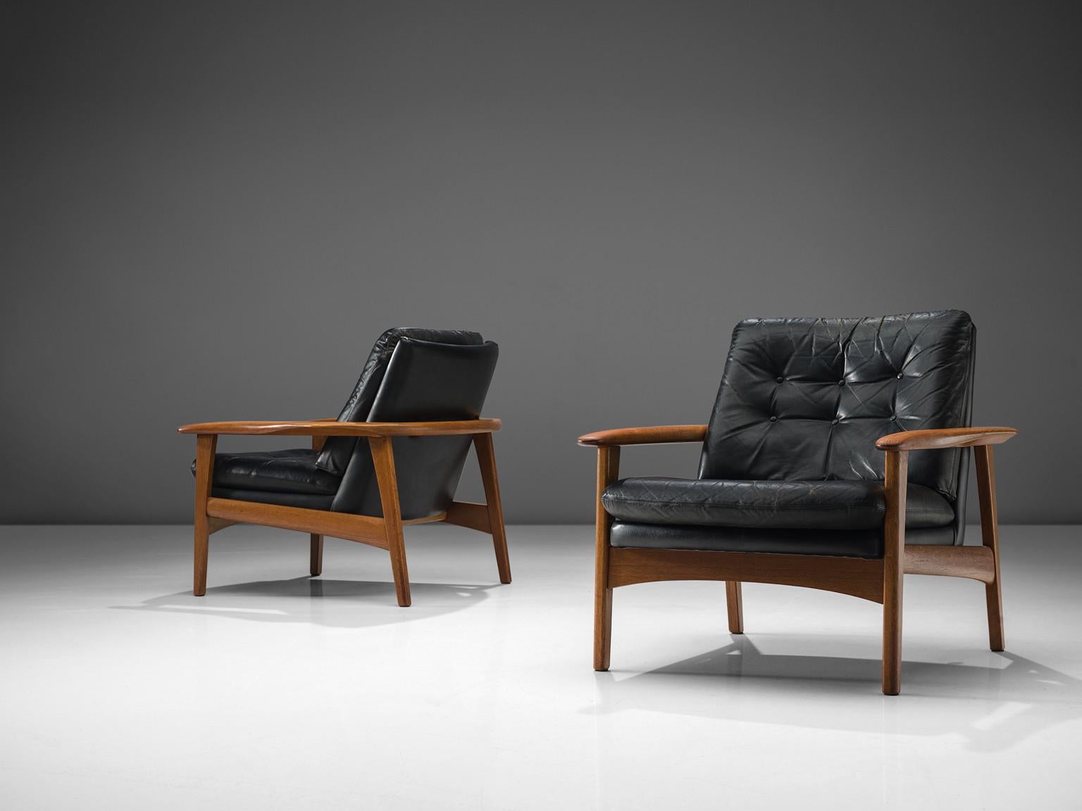 Pair of easy chairs, black leather and teak, Denmark, 1960s. 

This set of club like easy chairs feature a teak frame with and a tufted back. The chairs are modest, and their prime feature is their comfortable leather shell. The tufted seat and back