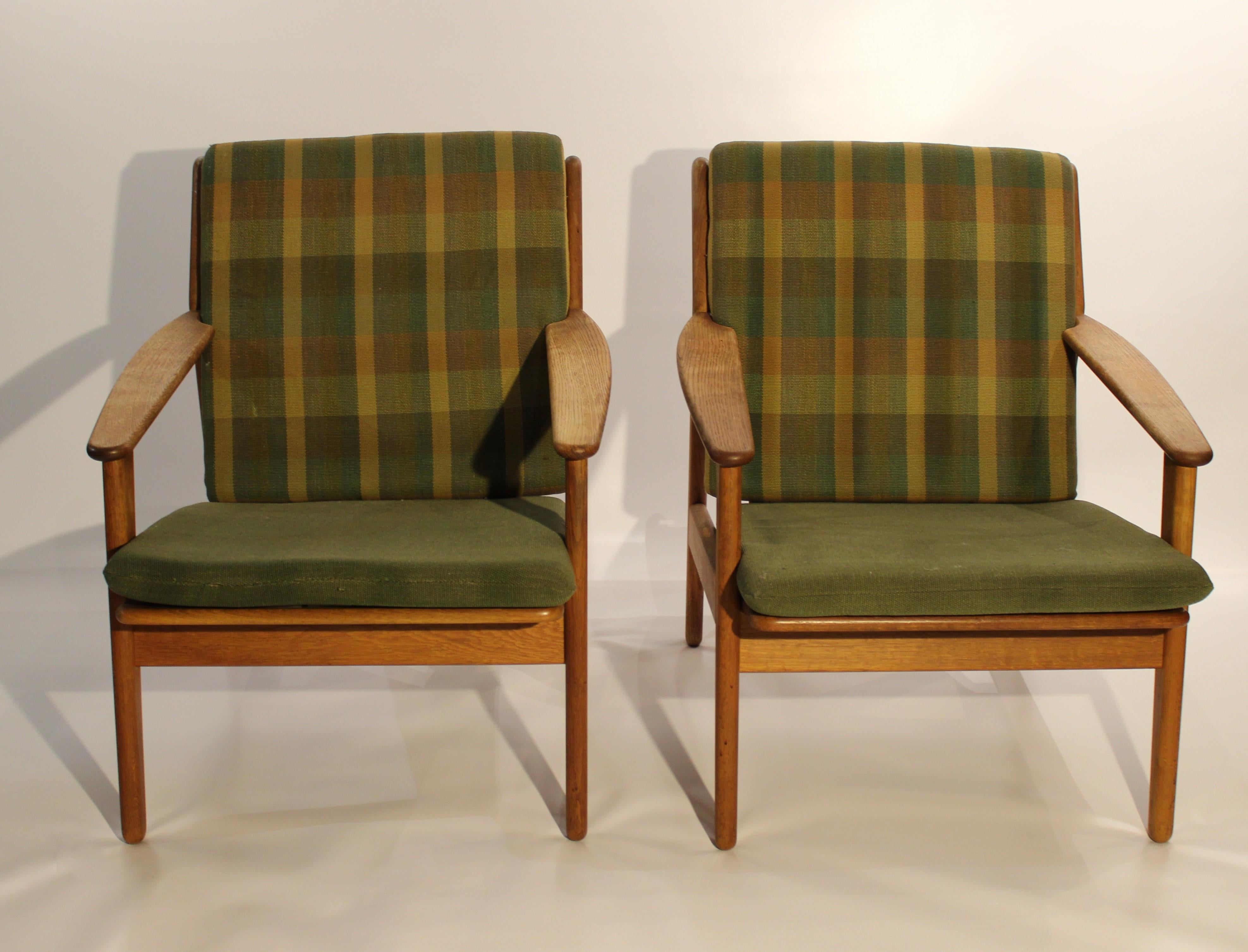 A pair of easy chairs in oak and upholstered with green fabric, model J55, designed by Poul M. Volther in 1953 and manufactured by FDB in 1961. The chairs are in great vintage condition.
 