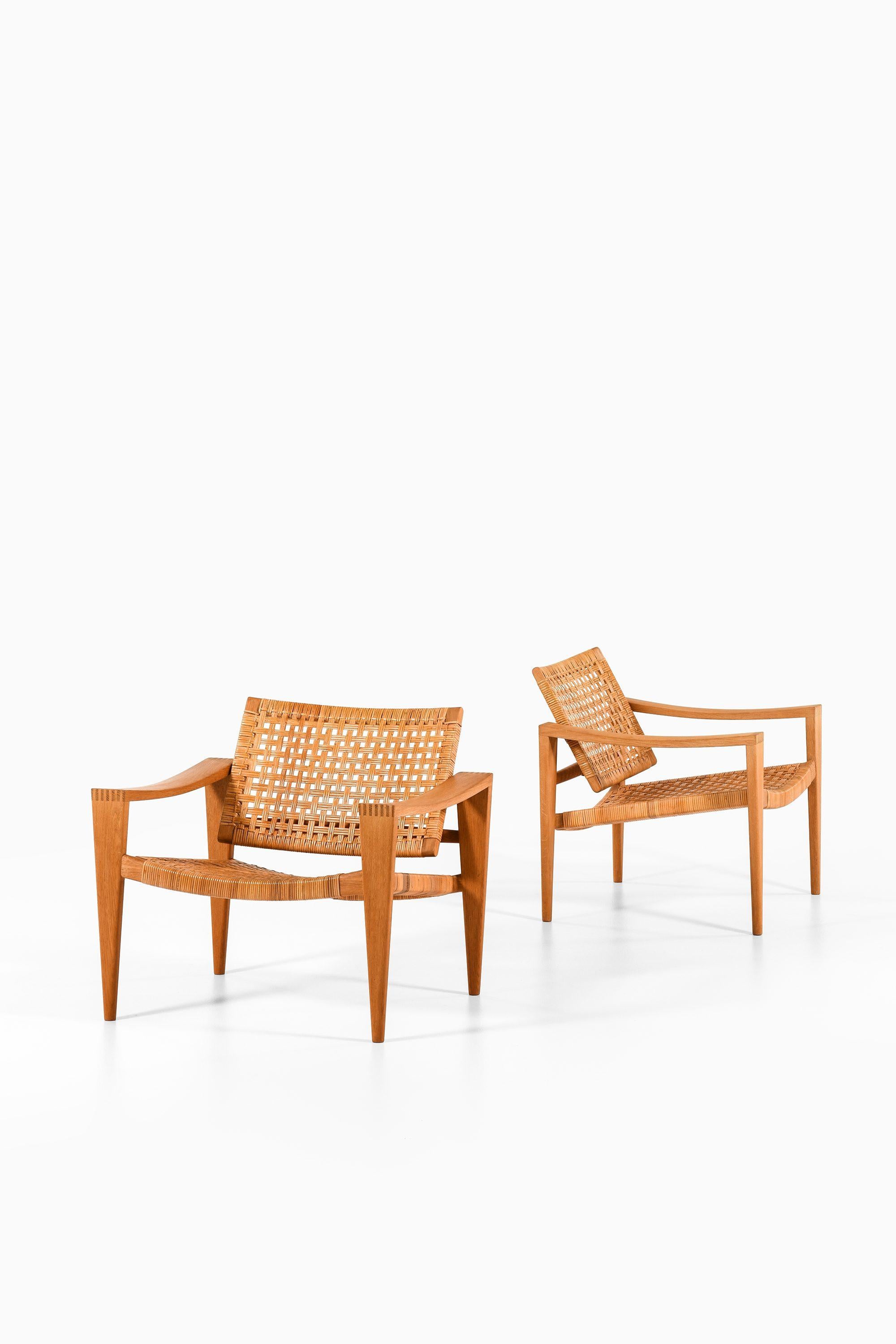 Mid-Century moderno Coppia di poltrone in Oak, canna intrecciata, ottone e pelle di Hans Wegner, 1959 in vendita