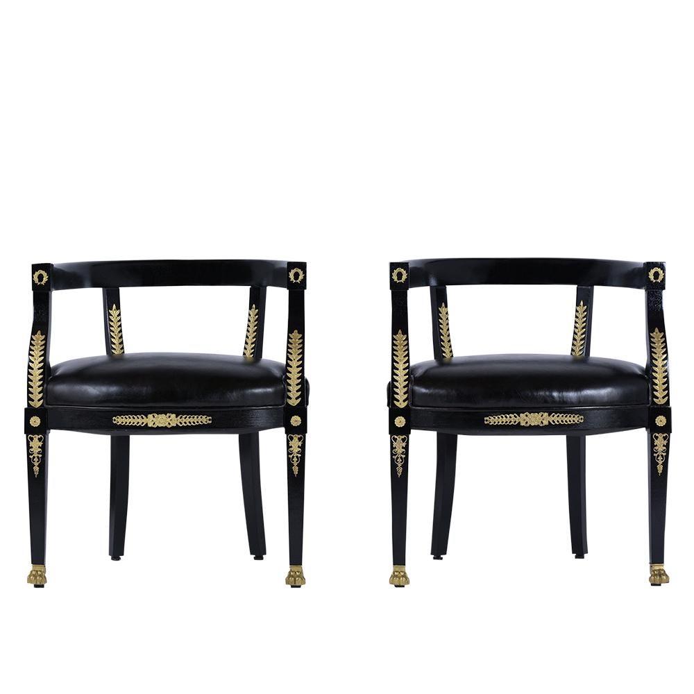 This pair of ebonized barrel back chairs are made out of mahogany wood and have been fully restored by our team of expert craftsmen. The armchairs have been professionally restained in ebonized color with a lacquered finish, feature finely carved